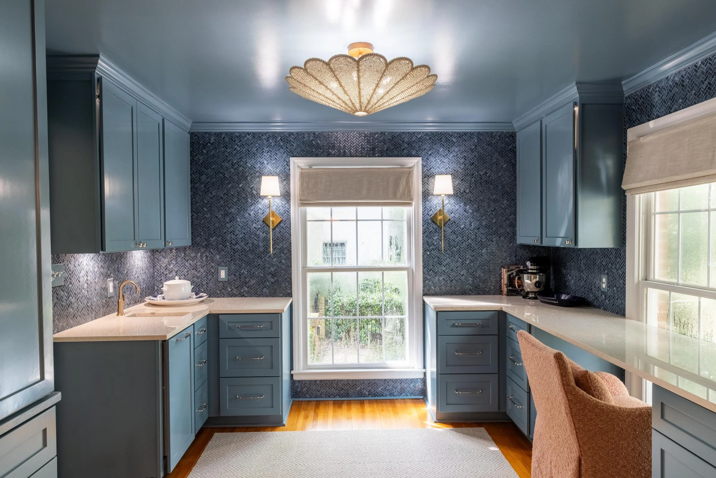 Butler's pantry with blue lacquered cabinetry, mosaic tile backsplash, and scalloped pendant light in a Charlotte, NC renovation