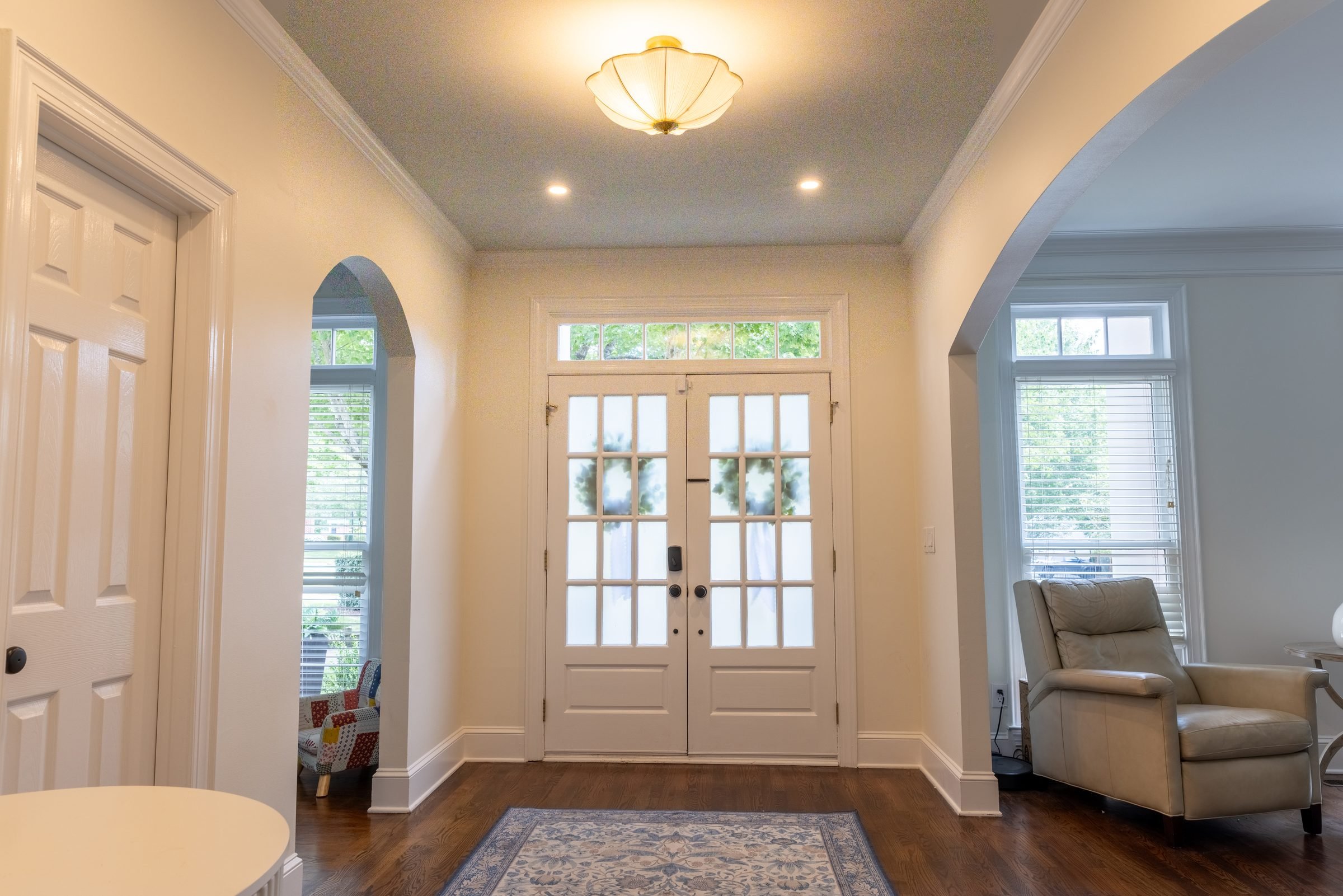 Arched entry hall with French front doors and crisp white trim from a Charlotte, NC whole-home renovation