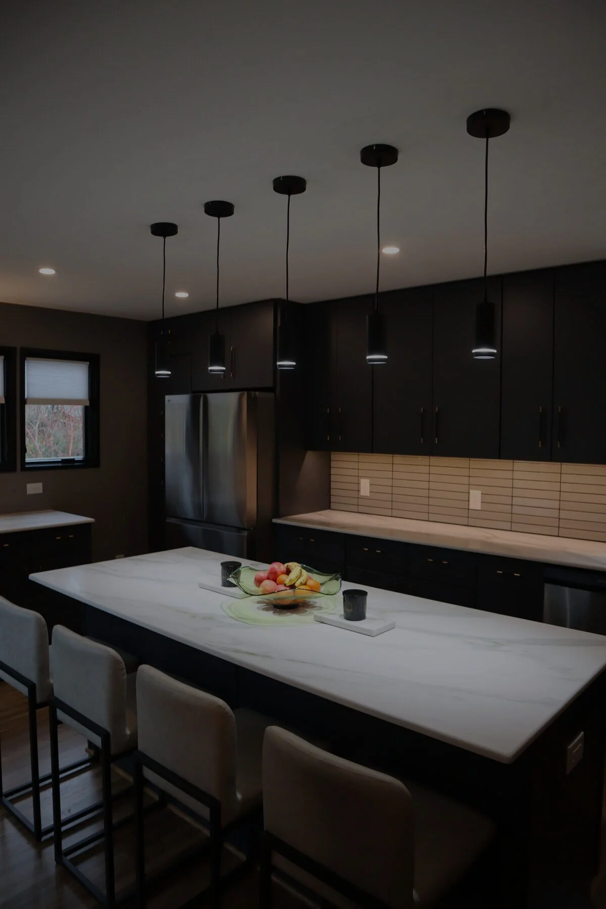 Modern kitchen remodel in Charlotte, NC with matte black custom cabinetry and waterfall marble island