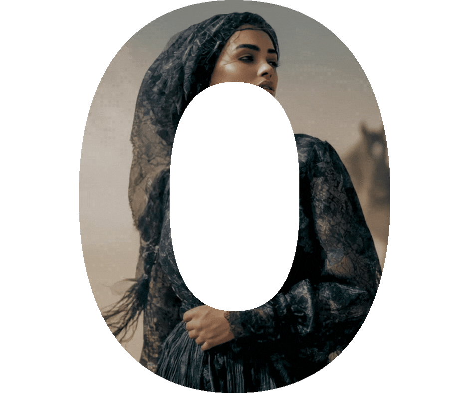 A woman wearing a lace hooded garment, standing outdoors with a blurred building in the background, partially obscured by a large black letter 'O' overlay. At YA SOKO