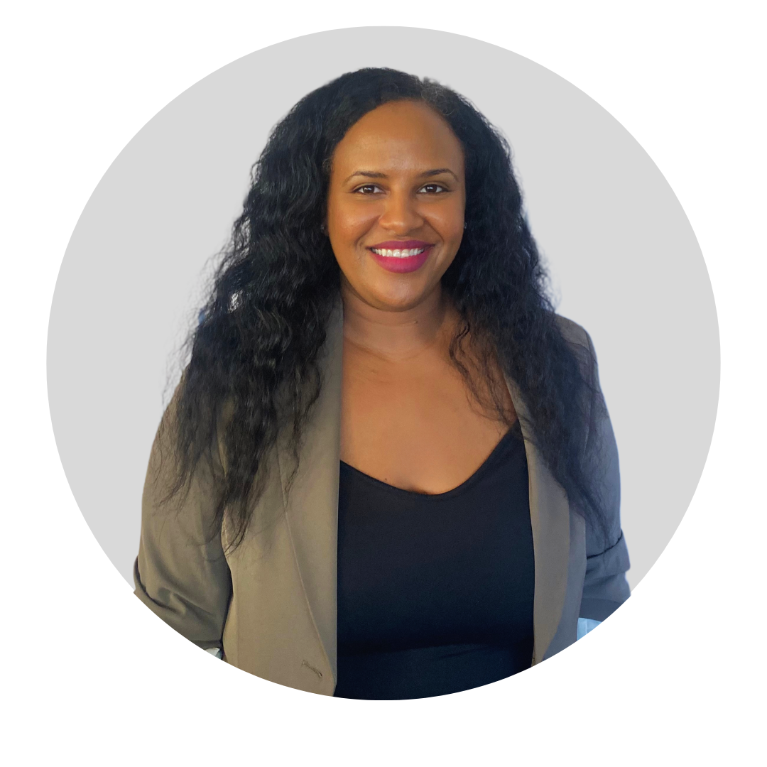 A woman with long, curly black hair, smiling, wearing a beige blazer over a black top, in front of a gray background with a circular border.
