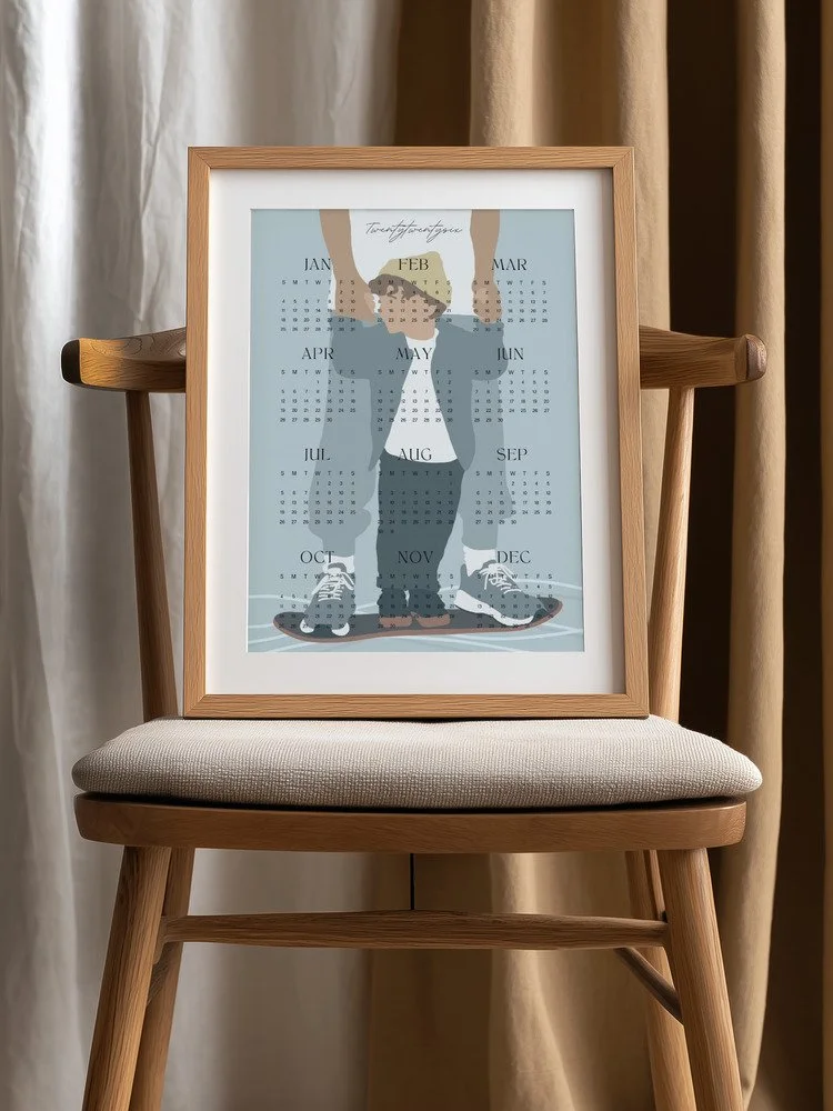 Minimalistischer Wandkalender 2026 von Tine Taler – das ganze Jahr auf einen Blick, mit Papa-Sohn-Motiv auf Skateboard in pastelligen Blautönen.