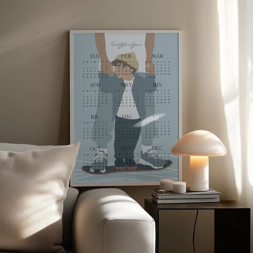 Minimalistischer Wandkalender 2026 von Tine Taler – das ganze Jahr auf einen Blick, mit Papa-Sohn-Motiv auf Skateboard in pastelligen Blautönen.