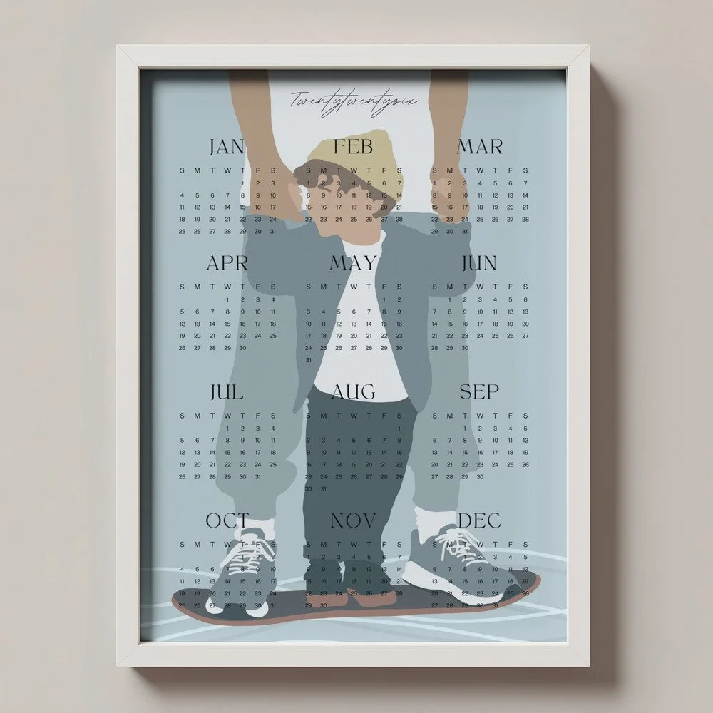 Minimalistischer Wandkalender 2026 von Tine Taler – das ganze Jahr auf einen Blick, mit Papa-Sohn-Motiv auf Skateboard in pastelligen Blautönen.