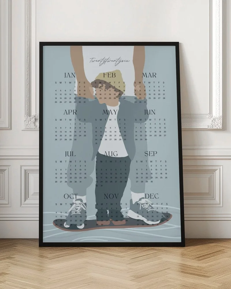 Minimalistischer Wandkalender 2026 von Tine Taler – das ganze Jahr auf einen Blick, mit Papa-Sohn-Motiv auf Skateboard in pastelligen Blautönen.