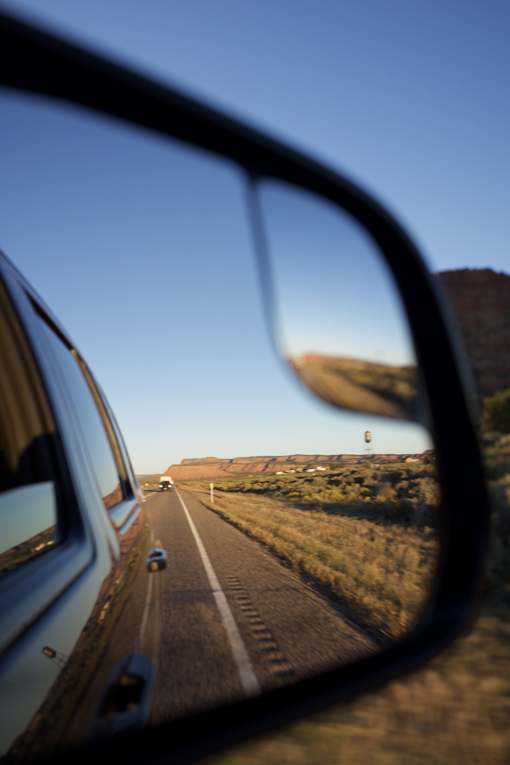 Desert landscape and road reflected in a car side mirror – Travel photography by Dario Caduff.