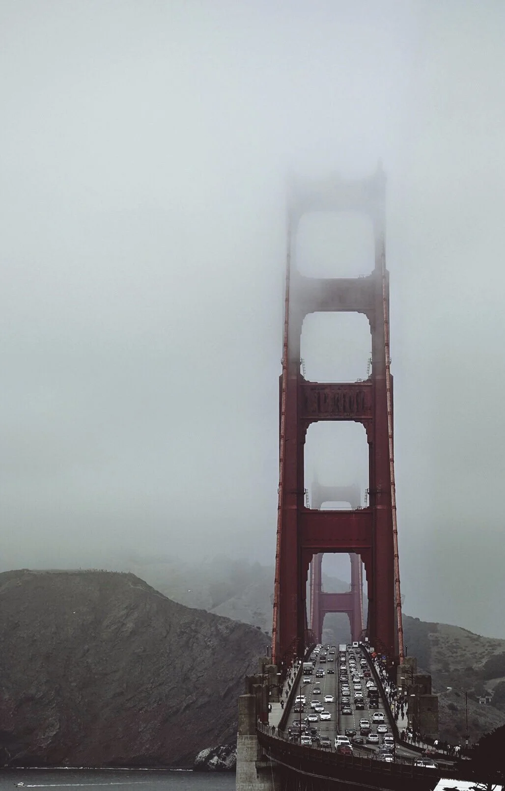 Die Golden Gate Bridge in San Francisco, umgeben von Nebel, mit Verkehr auf der Brücke.