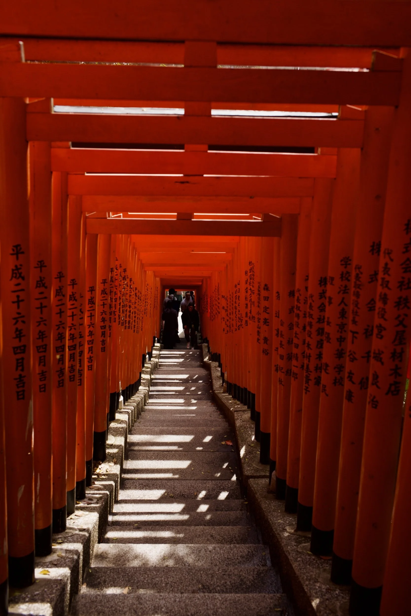 Rotkäppchen-Torweg auf einem Schreineingang in Japan, mit Kindern, die den Weg entlanggehen.