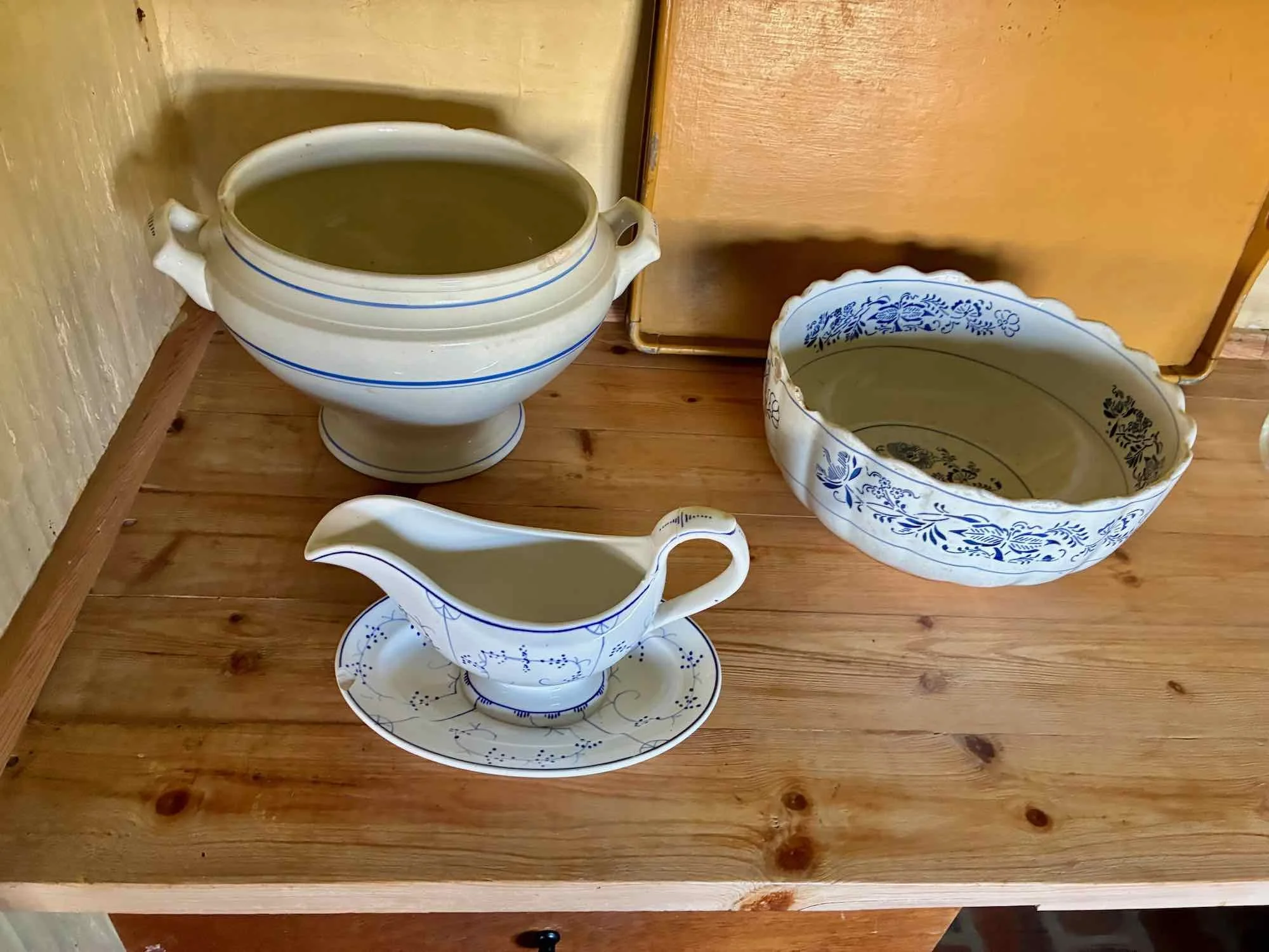 En kop og skål med blå ske i en træbord, glansfulde og med blå mønstre.