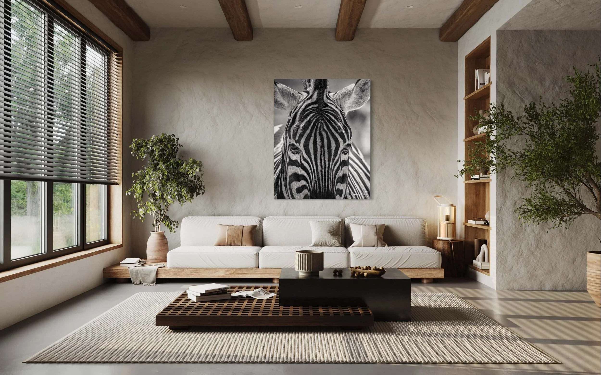 Modern living room with large window, white sofa, black coffee table, beige rug, framed zebra photograph on the wall, potted plants, wooden beams on ceiling, bookshelves with decorative items. Mock-up.