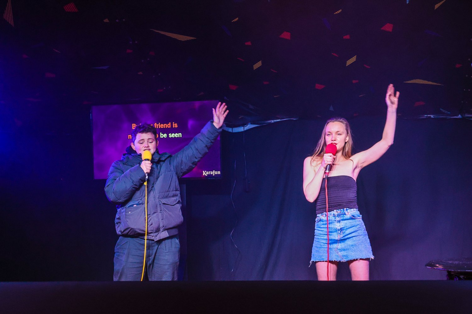 Two people performing karaoke.