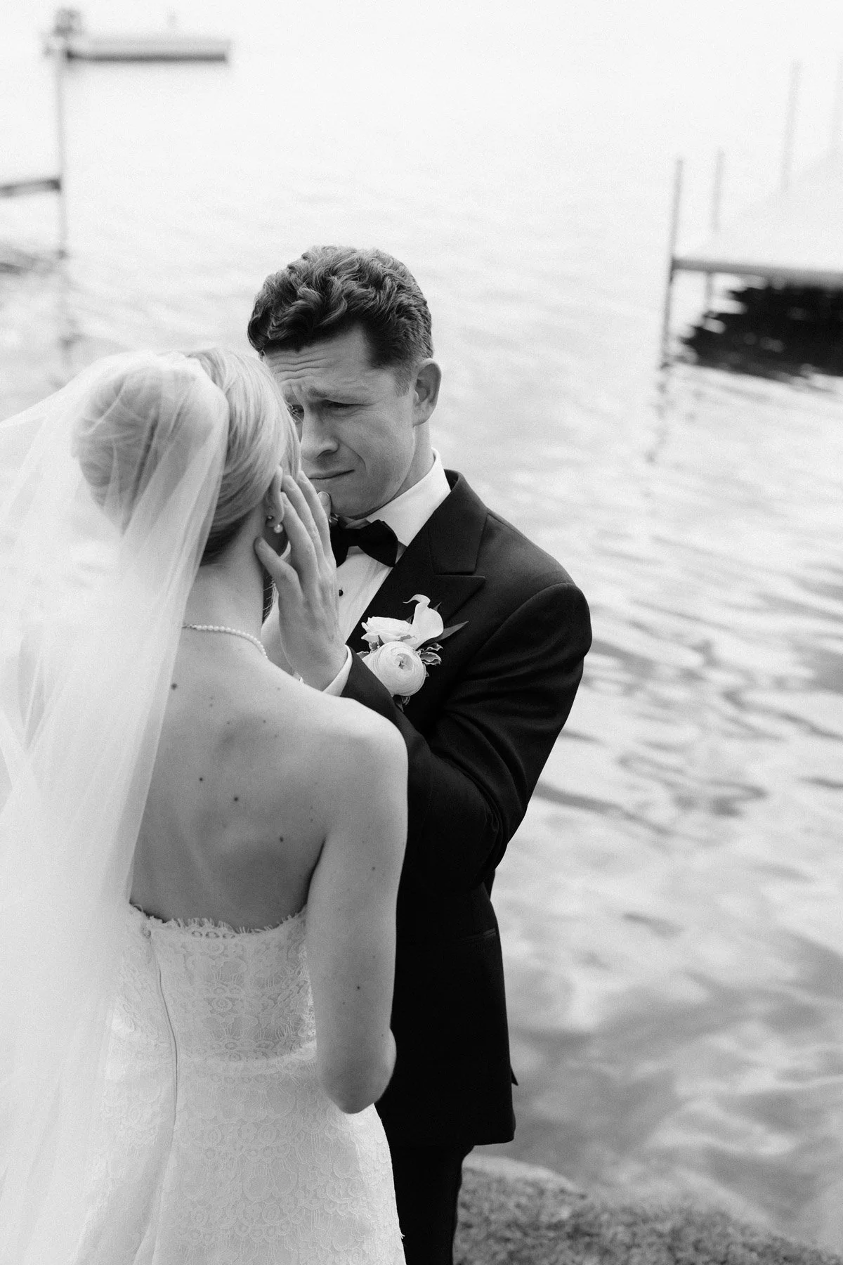 black and white images of a groom caressing his bride's face with water in background
