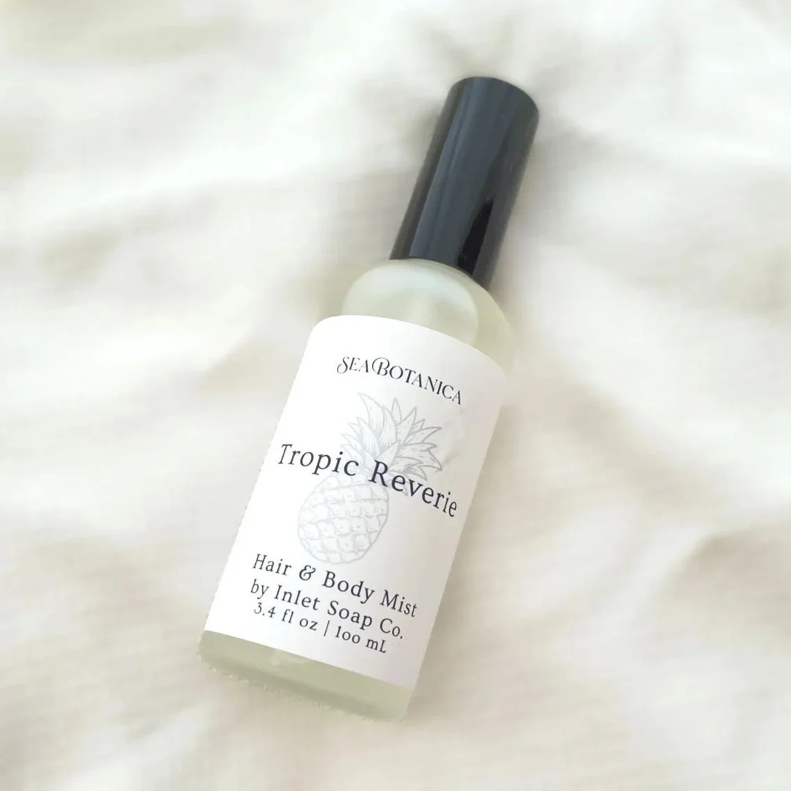 Frosted glass bottle with black top and Inlet Soap Co. label for Tropic Reverie, Hair & Body Mist.