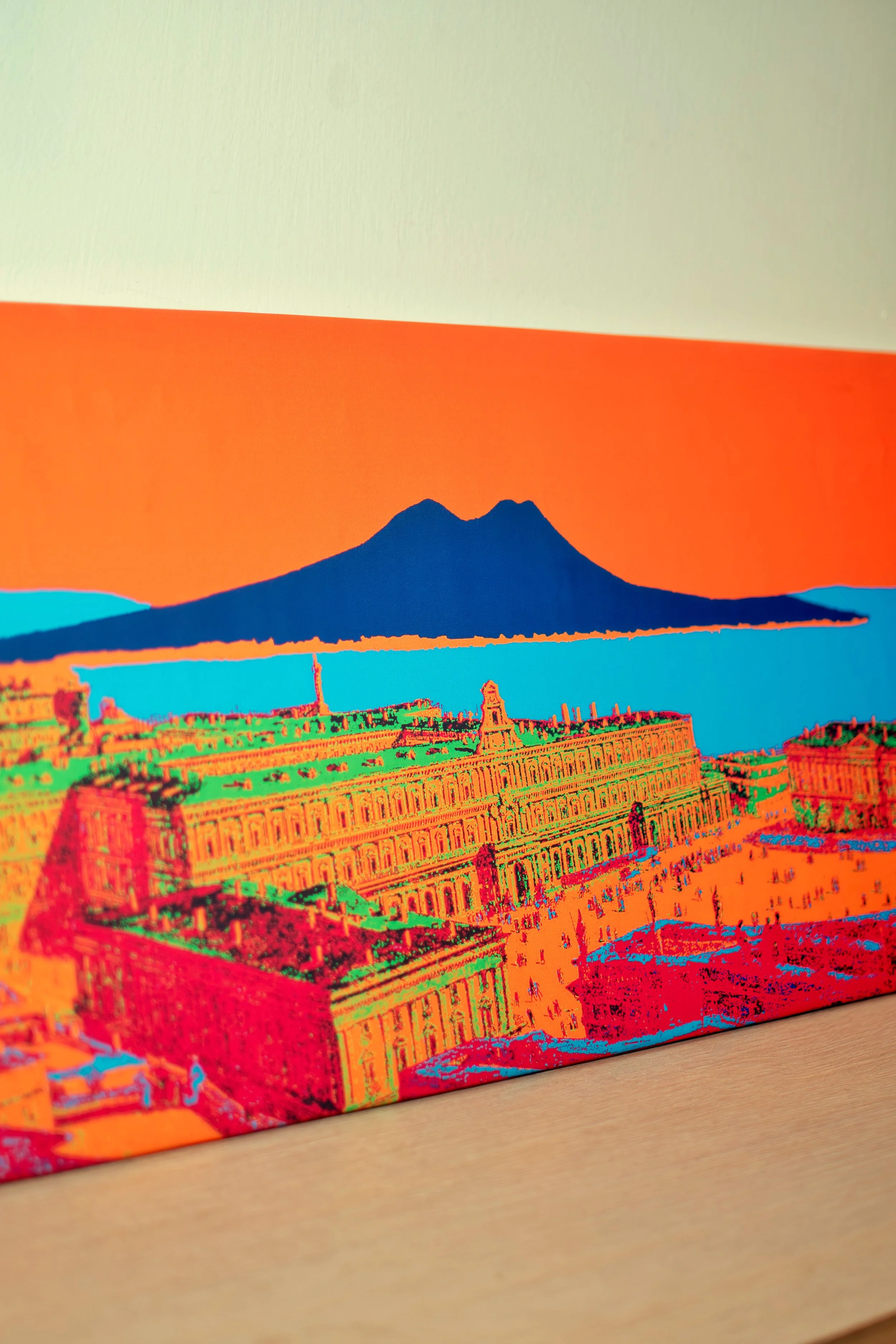 Colorful digital art of a cityscape with a mountain in the background, featuring vibrant orange, green, blue, and red hues.