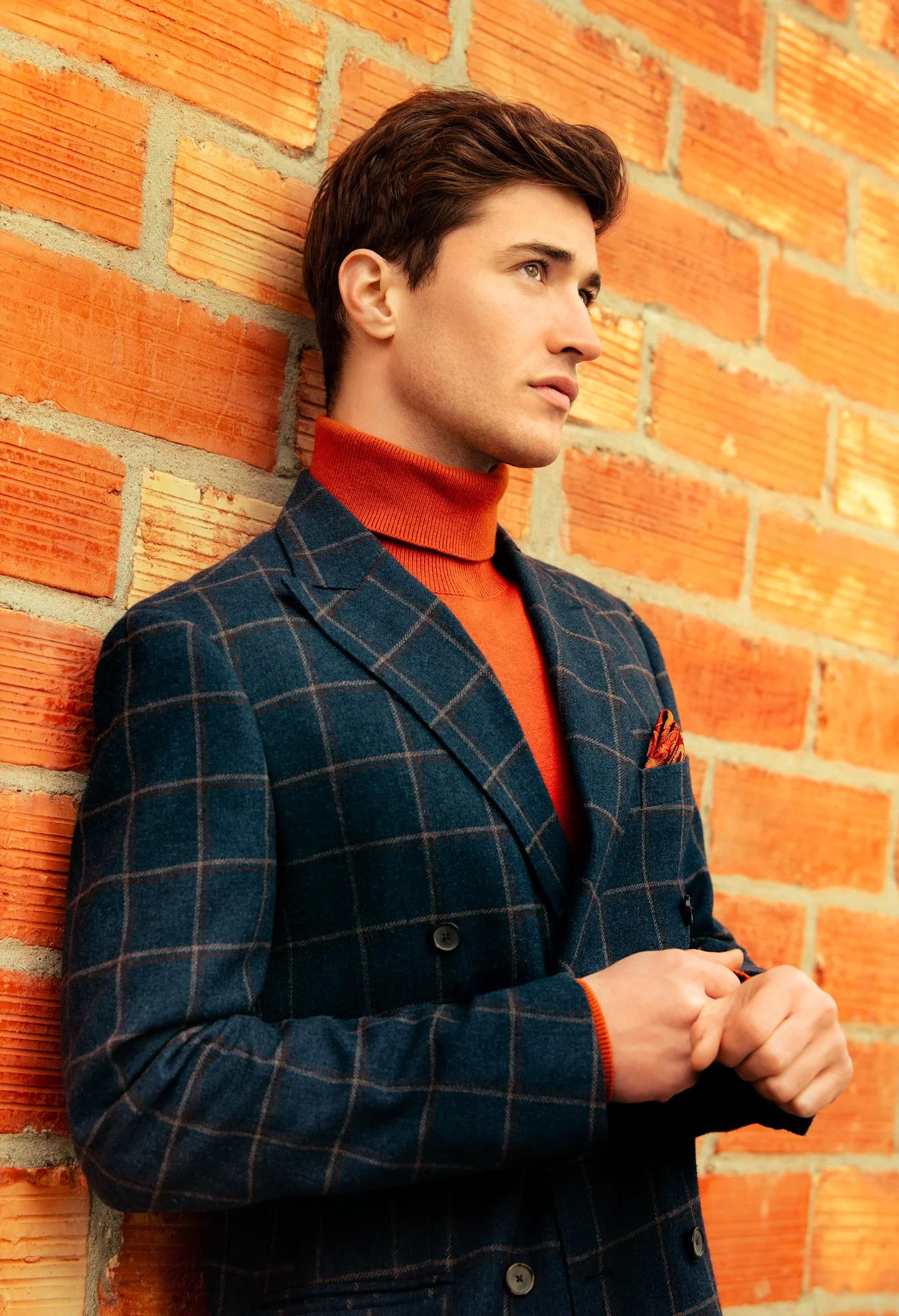 Guillaume-mur-en-briques-costume-à-carreaux-col-roulé-orange.jpg