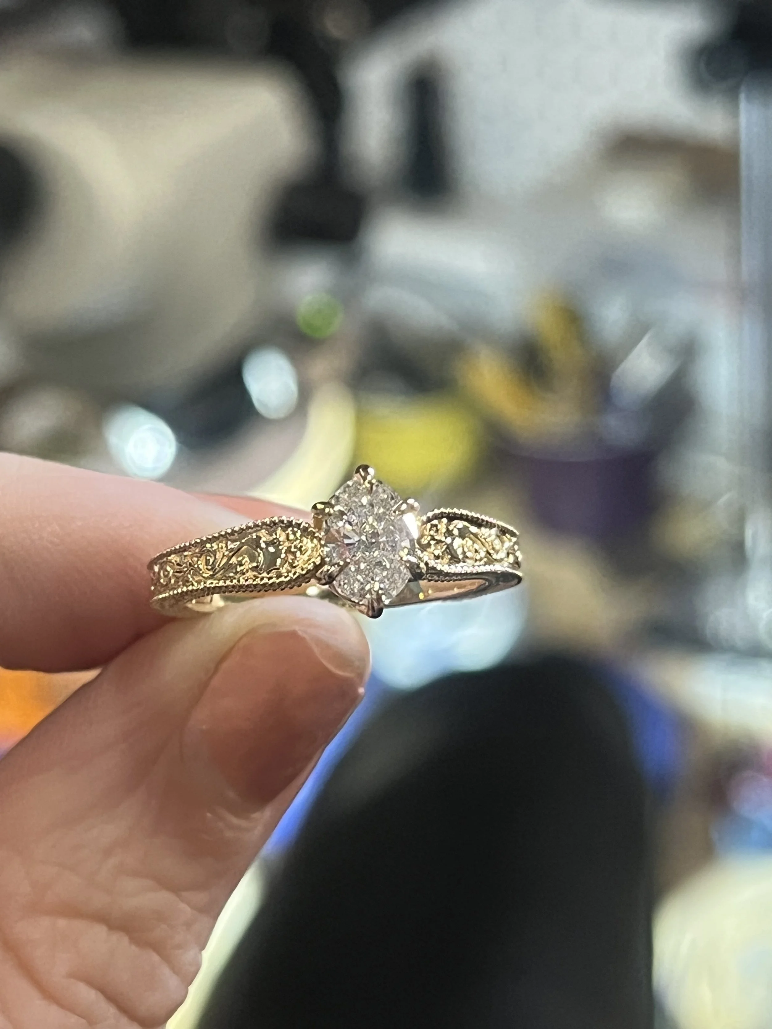 A custom made solitaire ring. Featuring vintage mil grain and filigree details on the band and a stunning oval diamond center stone