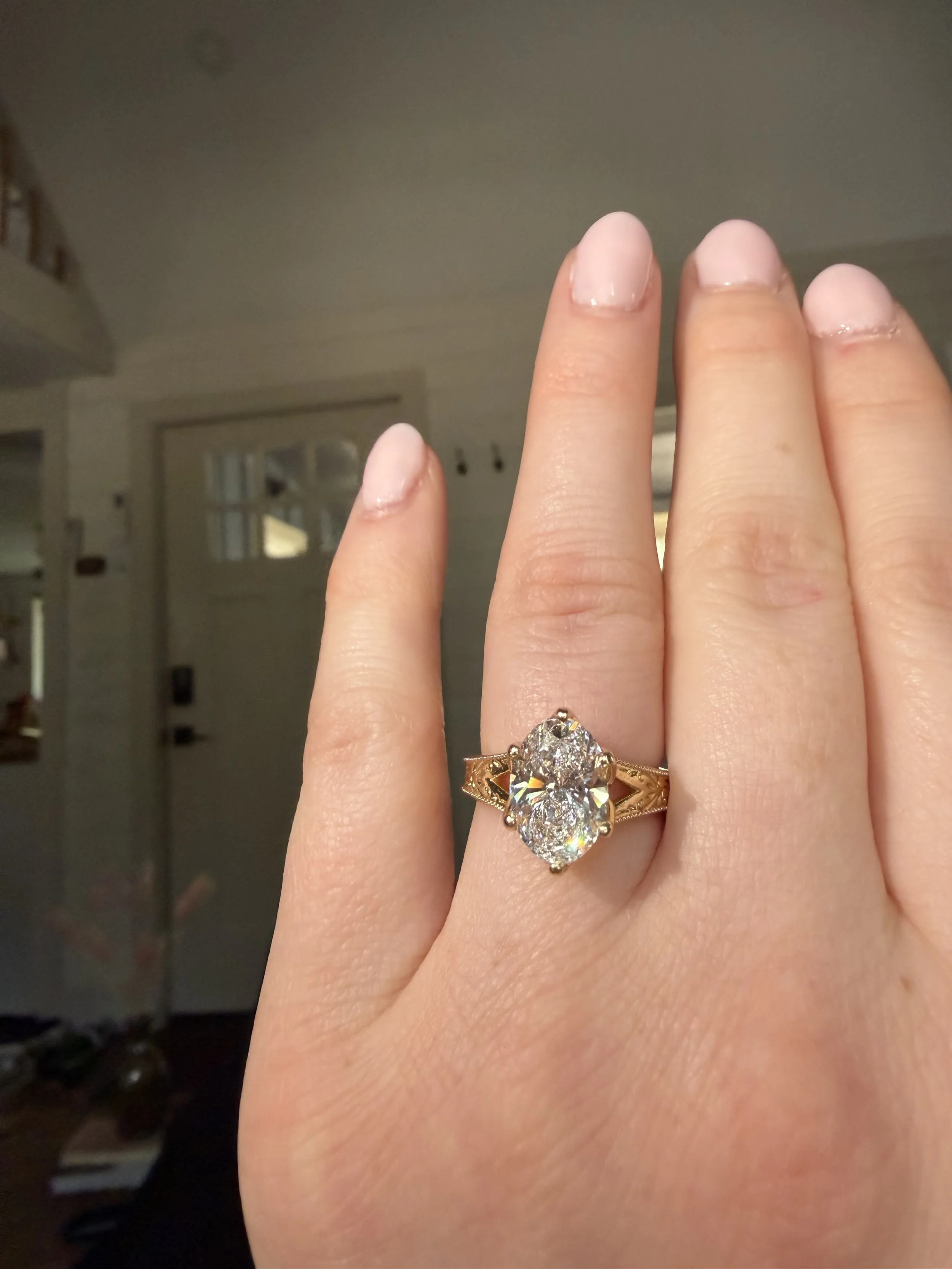 A close up photo of a bride-to-be showcasing her gorgeous custom made yellow gold diamond engagement ring by TSC Jewelry