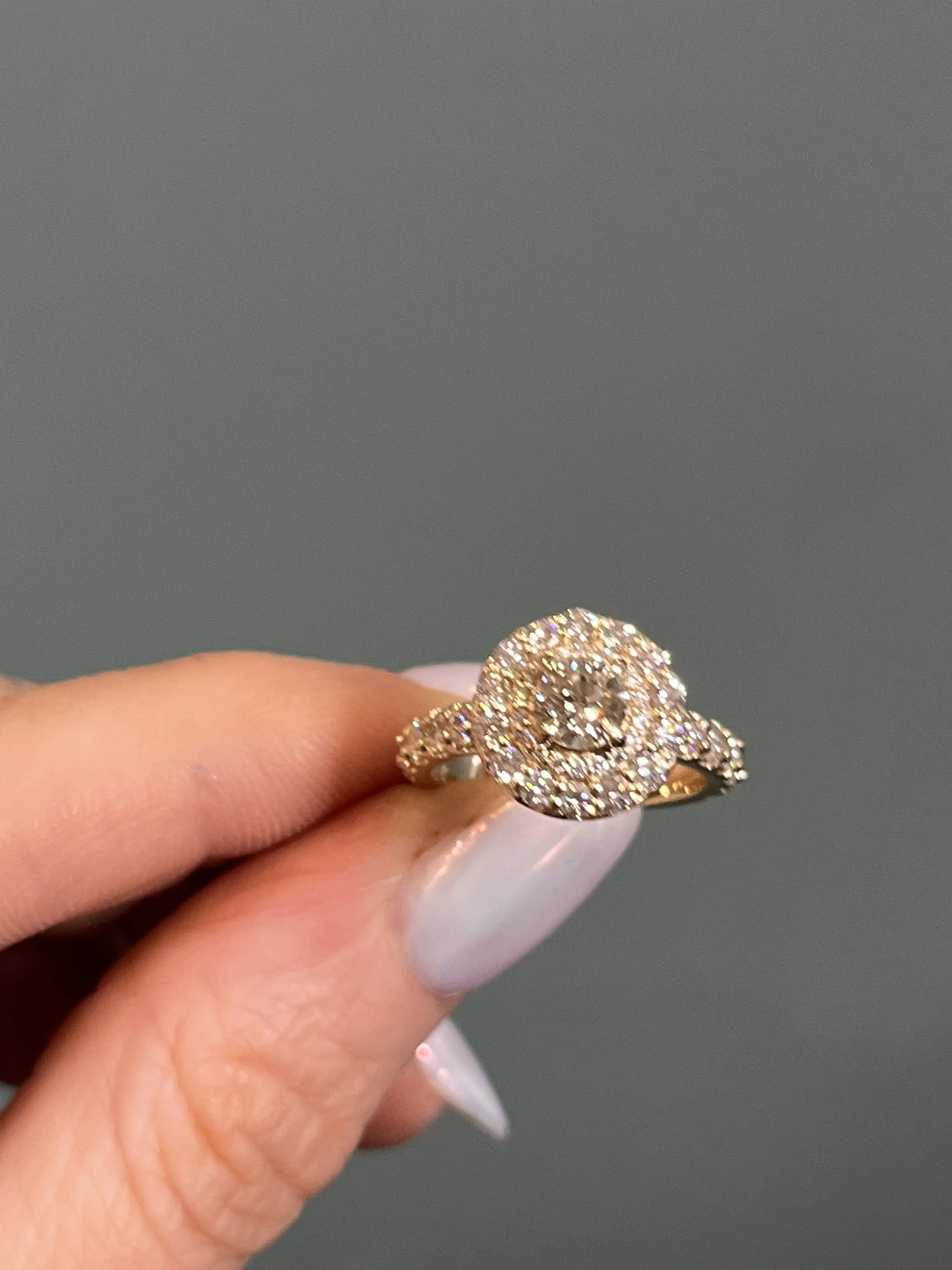A yellow gold ring featuring a gorgeous double halo of diamonds and an accented band, crafted by TSC Jewelry in Hartville Ohio