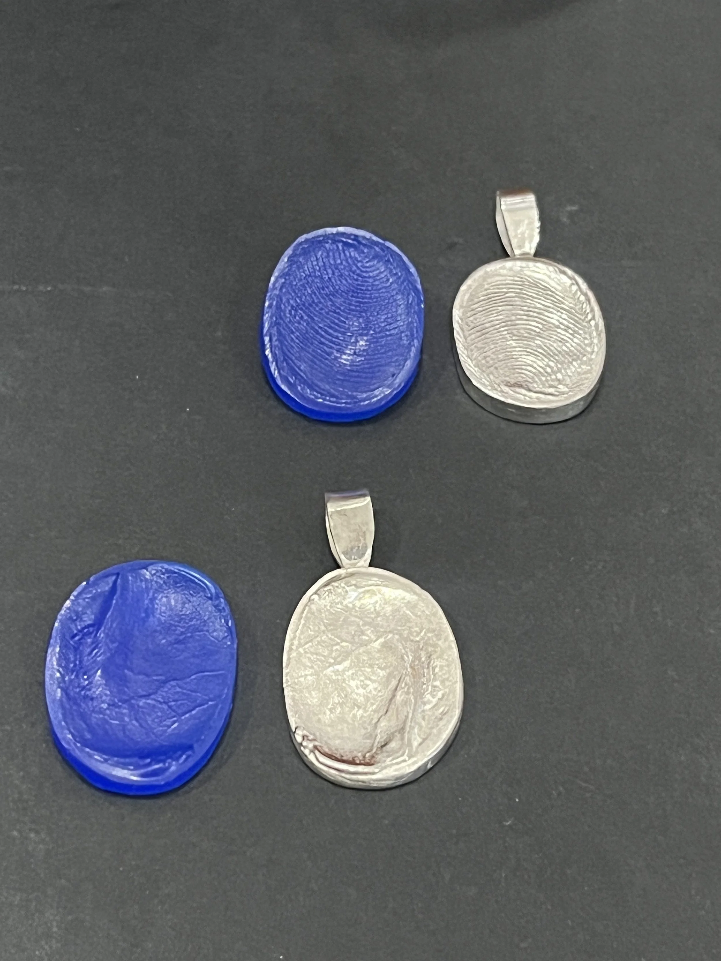 Custom fingerprint pendants by TSC Jewelry. Pendants are shown from the original wax imprint (in blue) to the final casted white gold thumbprint pendants