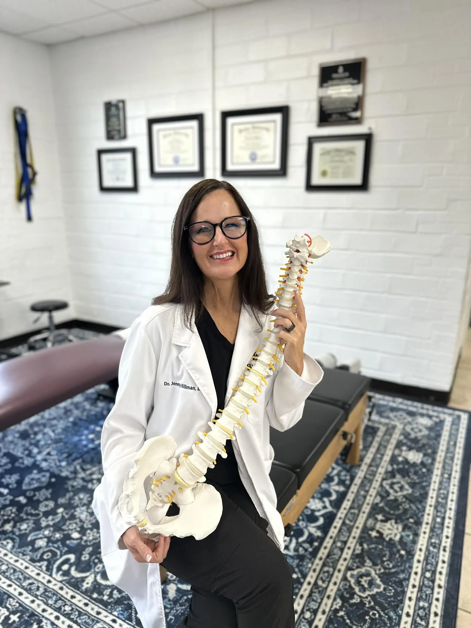 Dr Jenny Billman DC Holding a spine model.