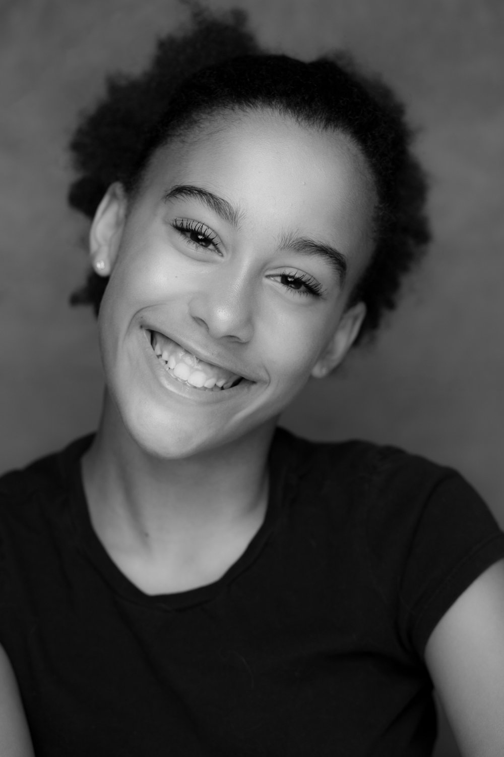 smiling girl black and white portrait in studio with grey background