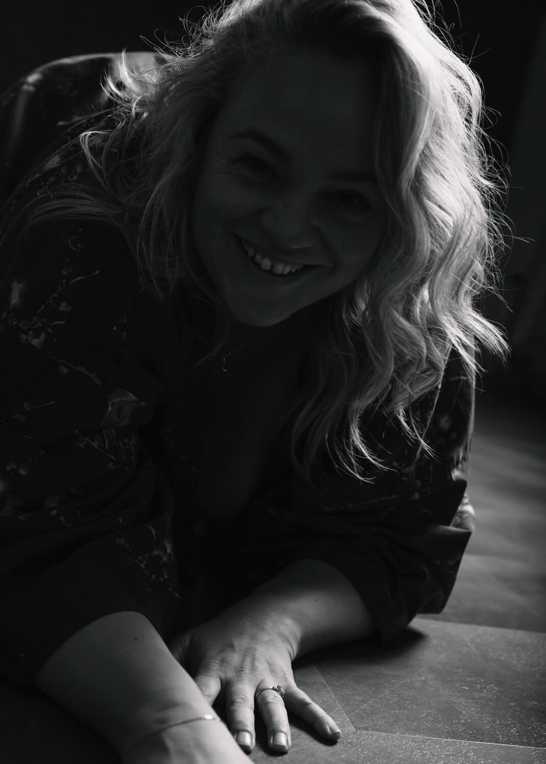 silhouette image of woman on hand and knees smiling into camera