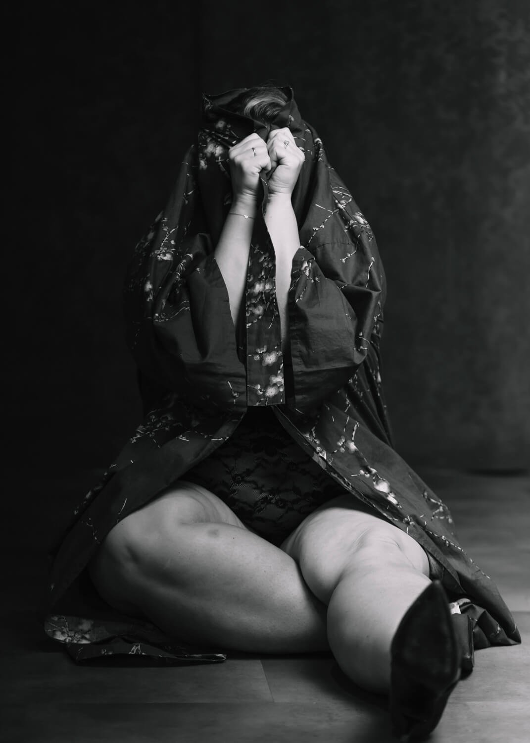 black and white image of woman hiding in her kimono as playing hide and seek