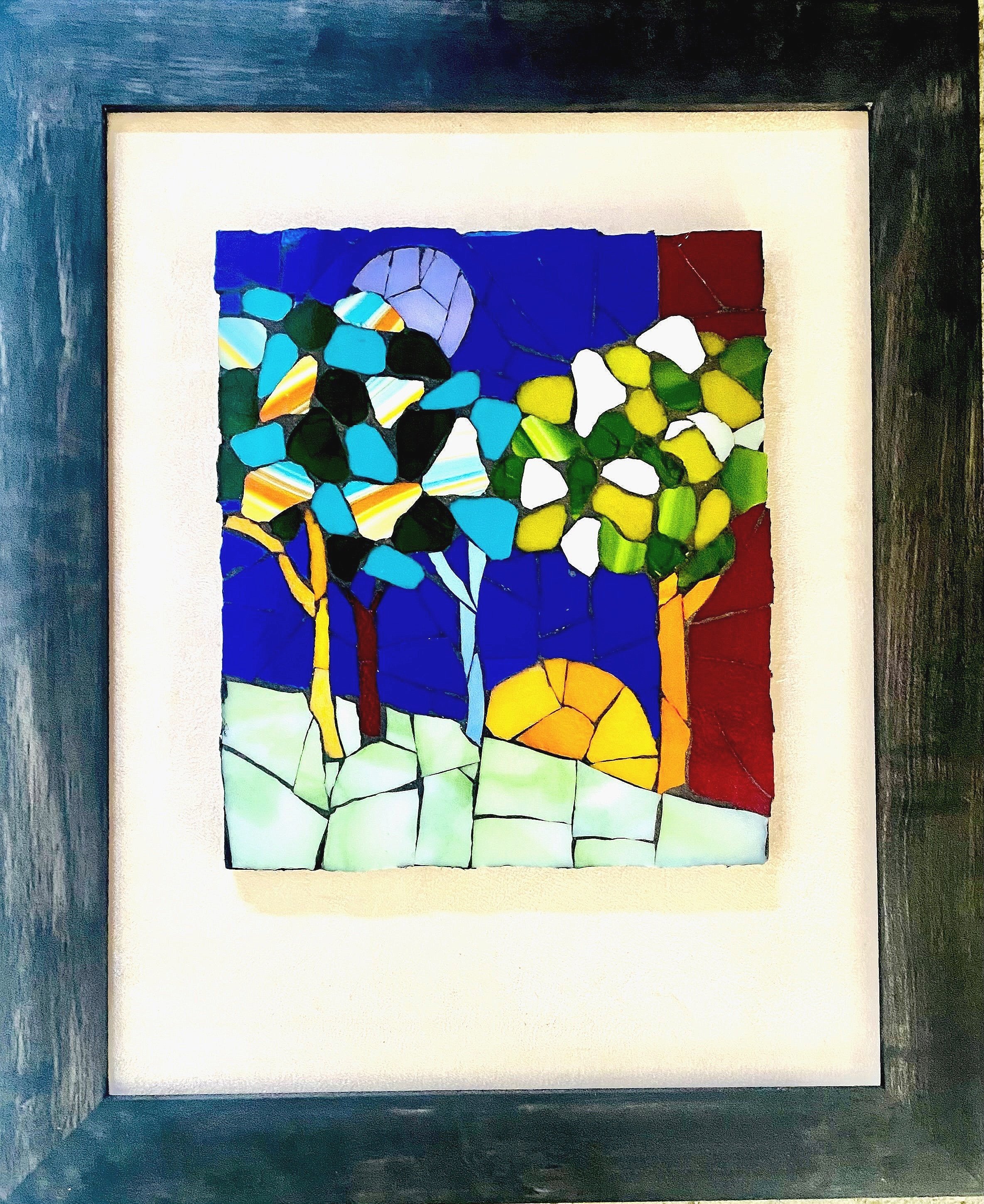 Framed glass mosaic of three trees on pale green ground with a deep blue sky, a yellow-orange circle near the horizon, and a purple circle above