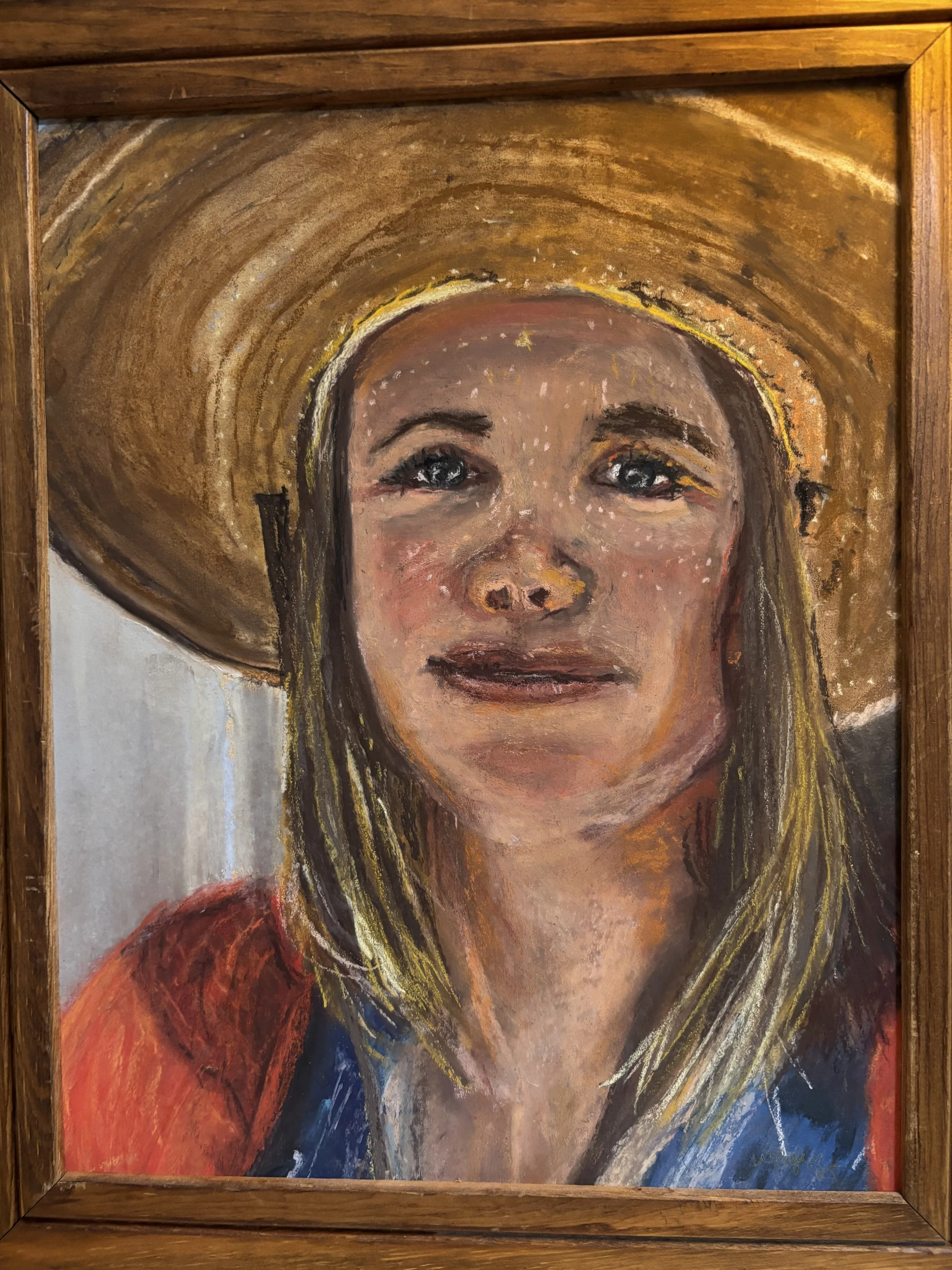 A portrait painting of a woman wearing a large straw hat with a broad brim, with shoulder-length blonde hair, and an expressive face against a simple background.