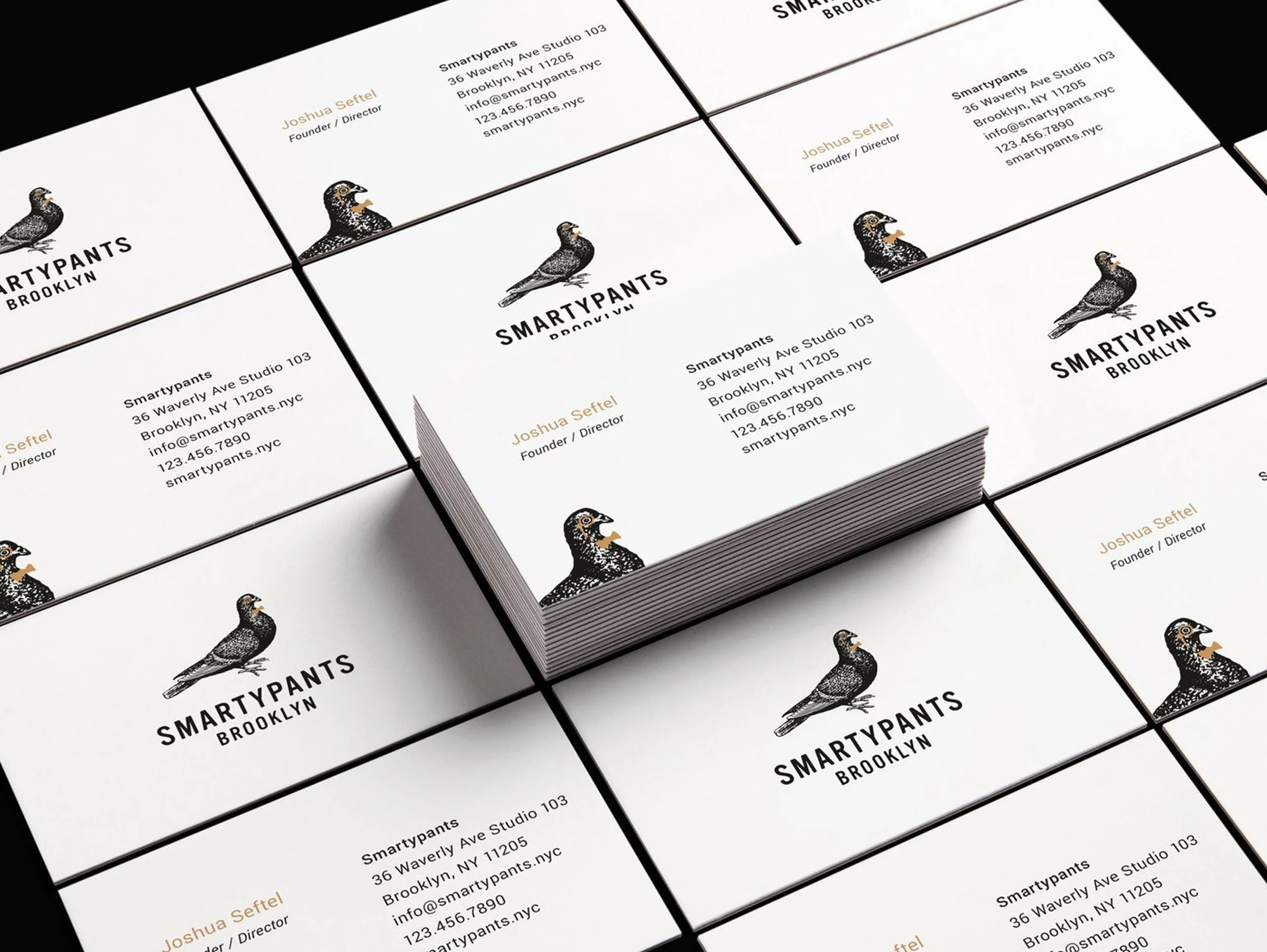 Stack of white business cards with a black and white bird illustration, black text reading 'SMARTYPANTS BROOKLYN,' and contact information for Joshua Seftel, founder and director.