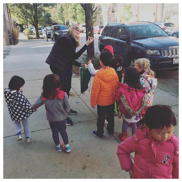 young kids out collecting leaves in the city with green explorers club