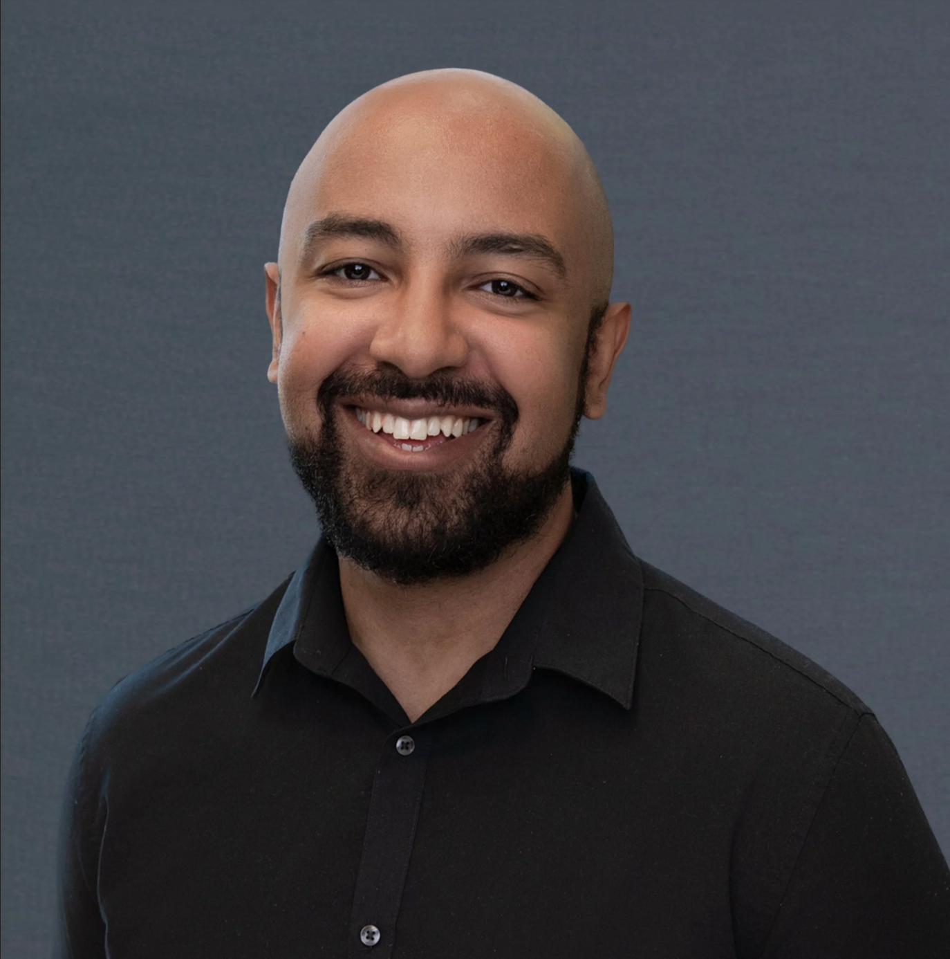 Professional conference headshot of a businessman in a black shirt for on-site company branding, corporate marketing, and LinkedIn profile use.