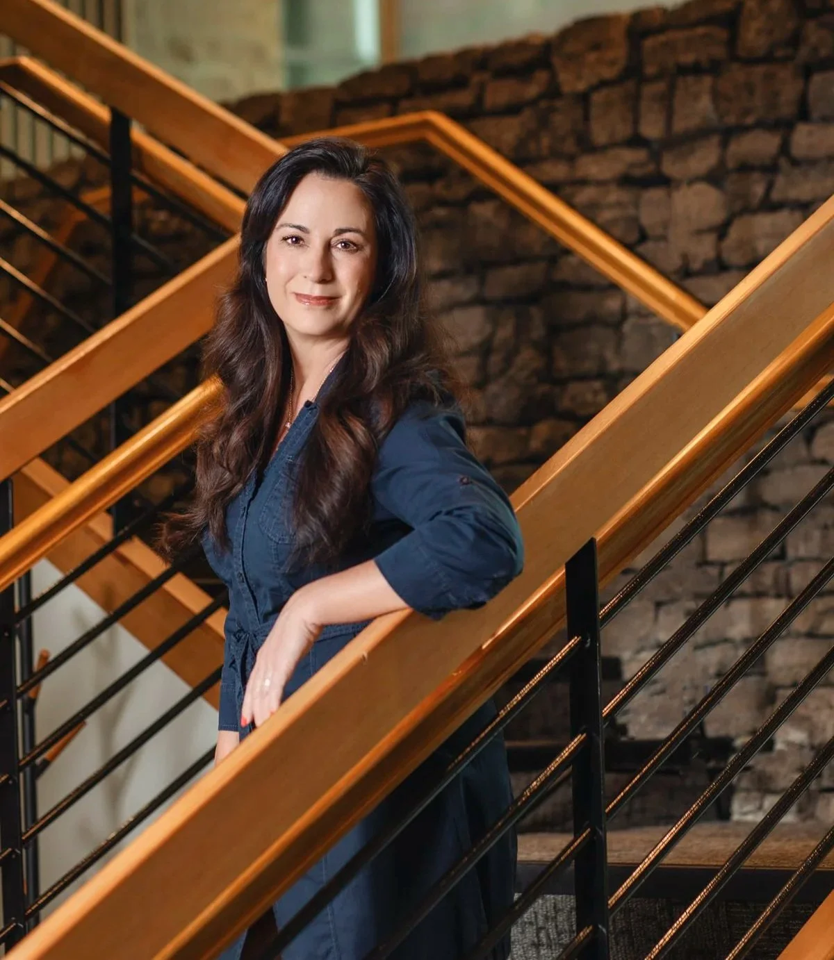Professional broker portrait for Avenir Realty featuring a businesswoman standing on a modern staircase for marketing, branding, and website headshot photography.