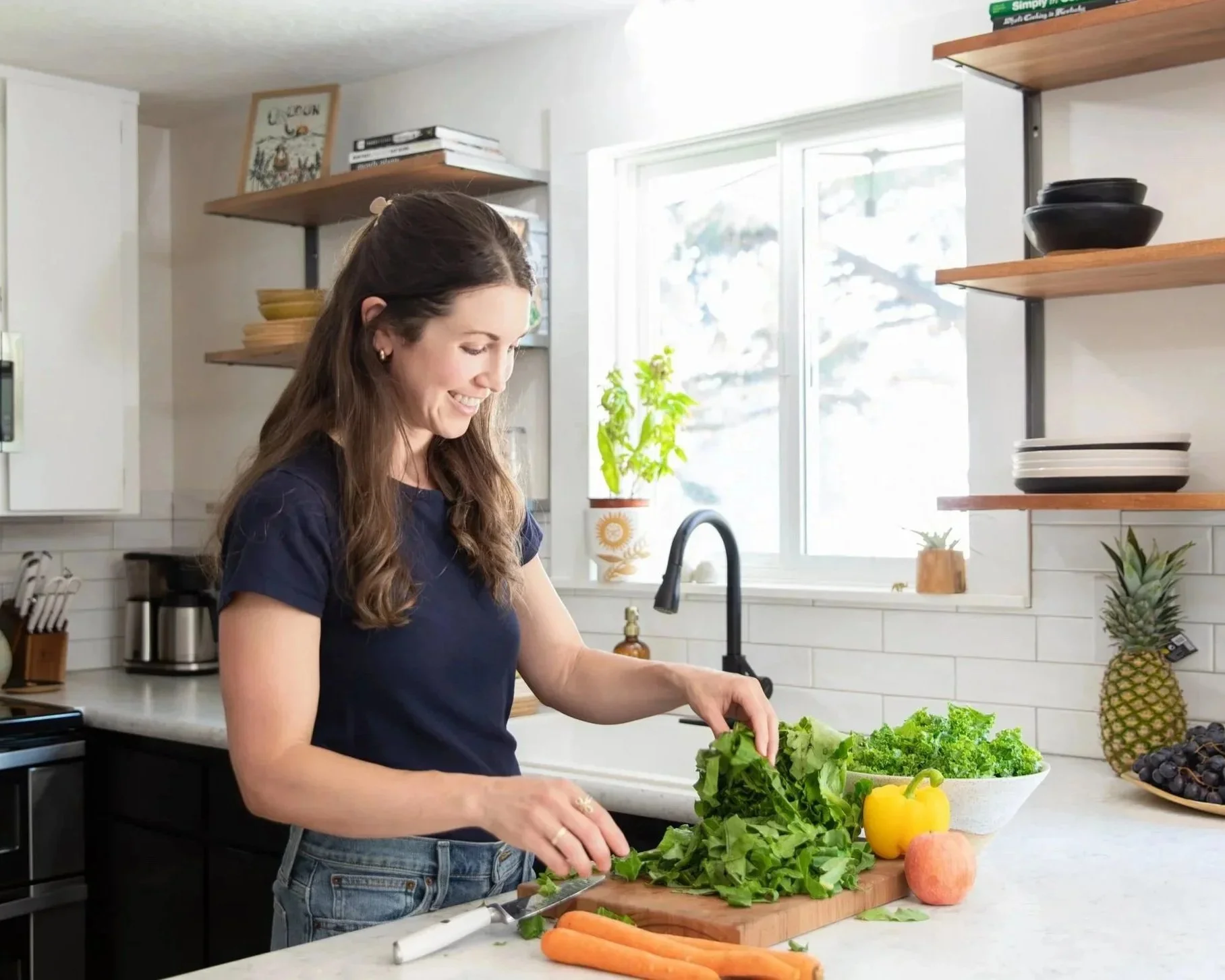 Nutritional specialist and entrepreneur preparing fresh vegetables in a bright modern kitchen during a personal branding photo session.