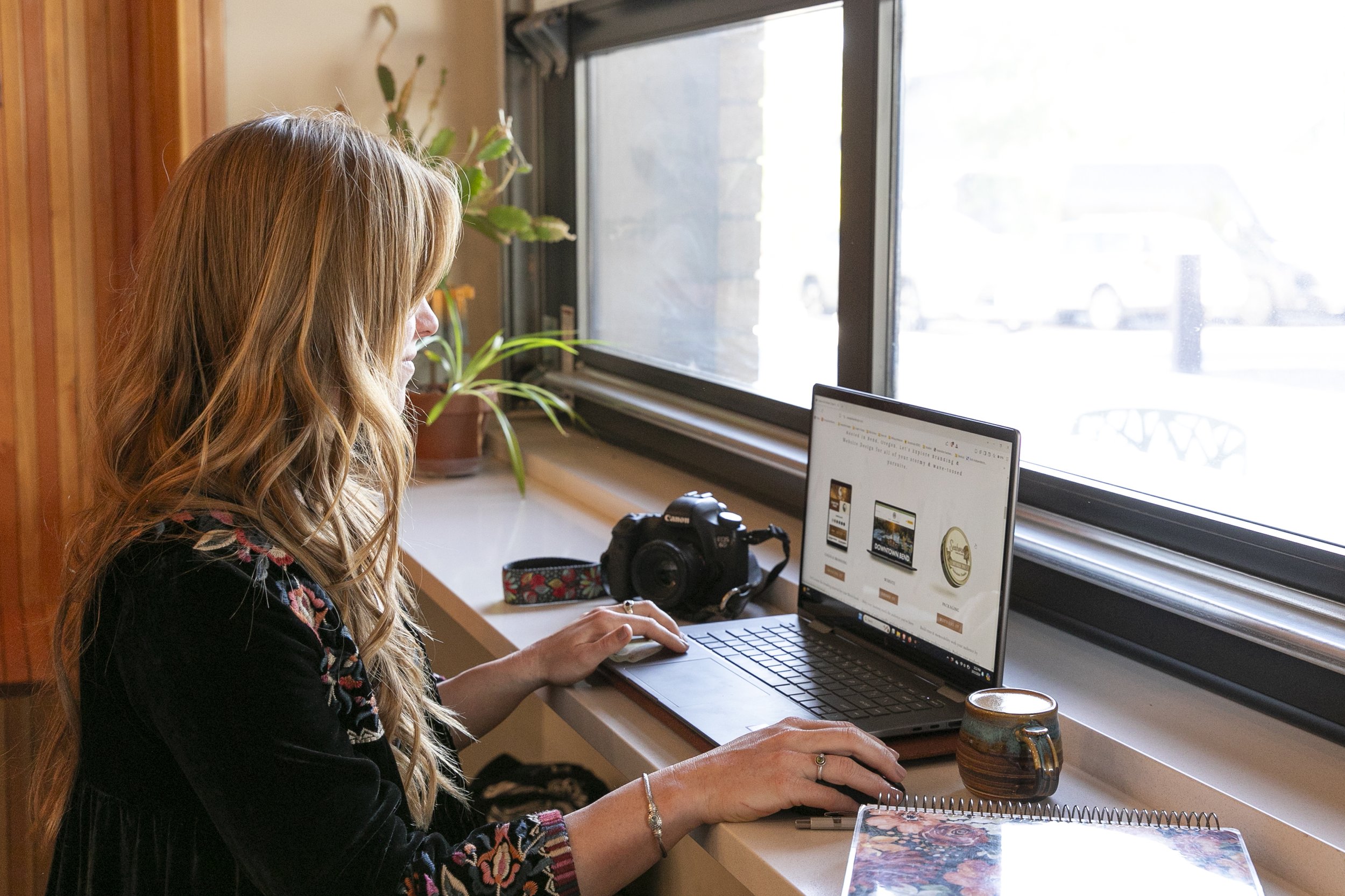 Graphic and web designer working on laptop creating bold and unique brand designs for business clients
