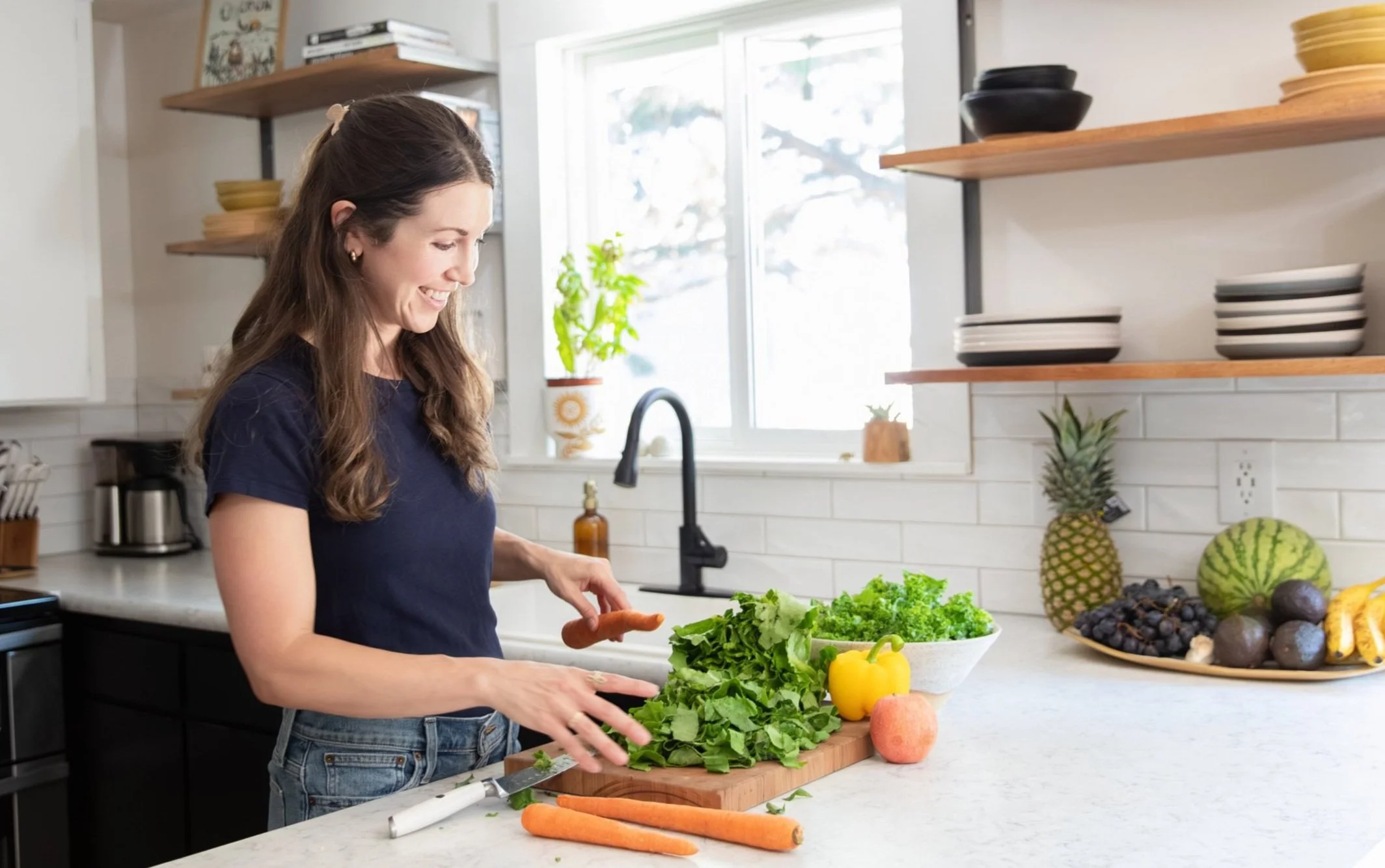 Lifestyle branding photo of nutritionist preparing fresh vegetables in bright kitchen in Bend Oregon