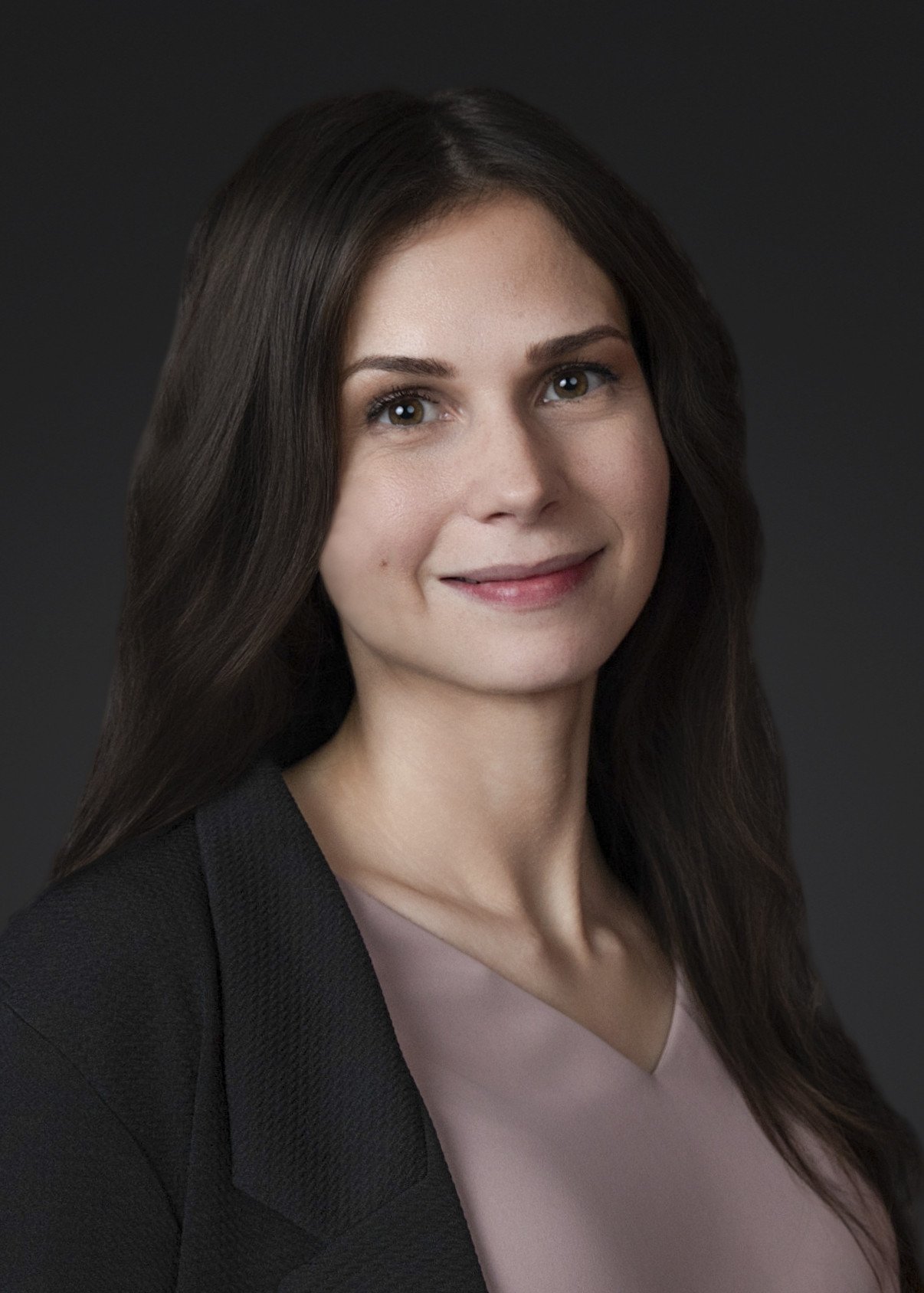 Professional business headshot of woman with natural expression and soft lighting