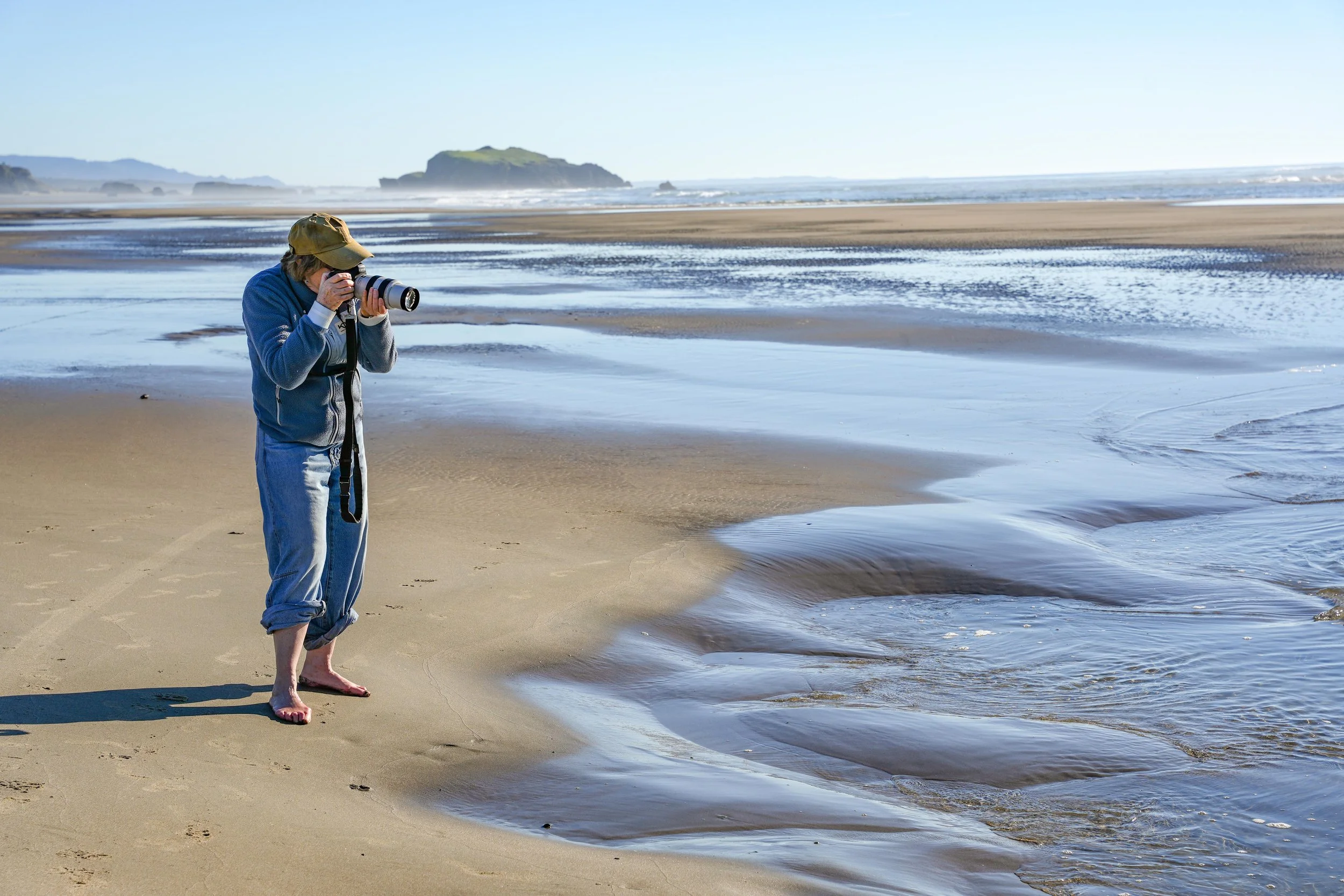 Photographer on location in Bandon Oregon capturing coastal images on the beach during a professional photo shoot