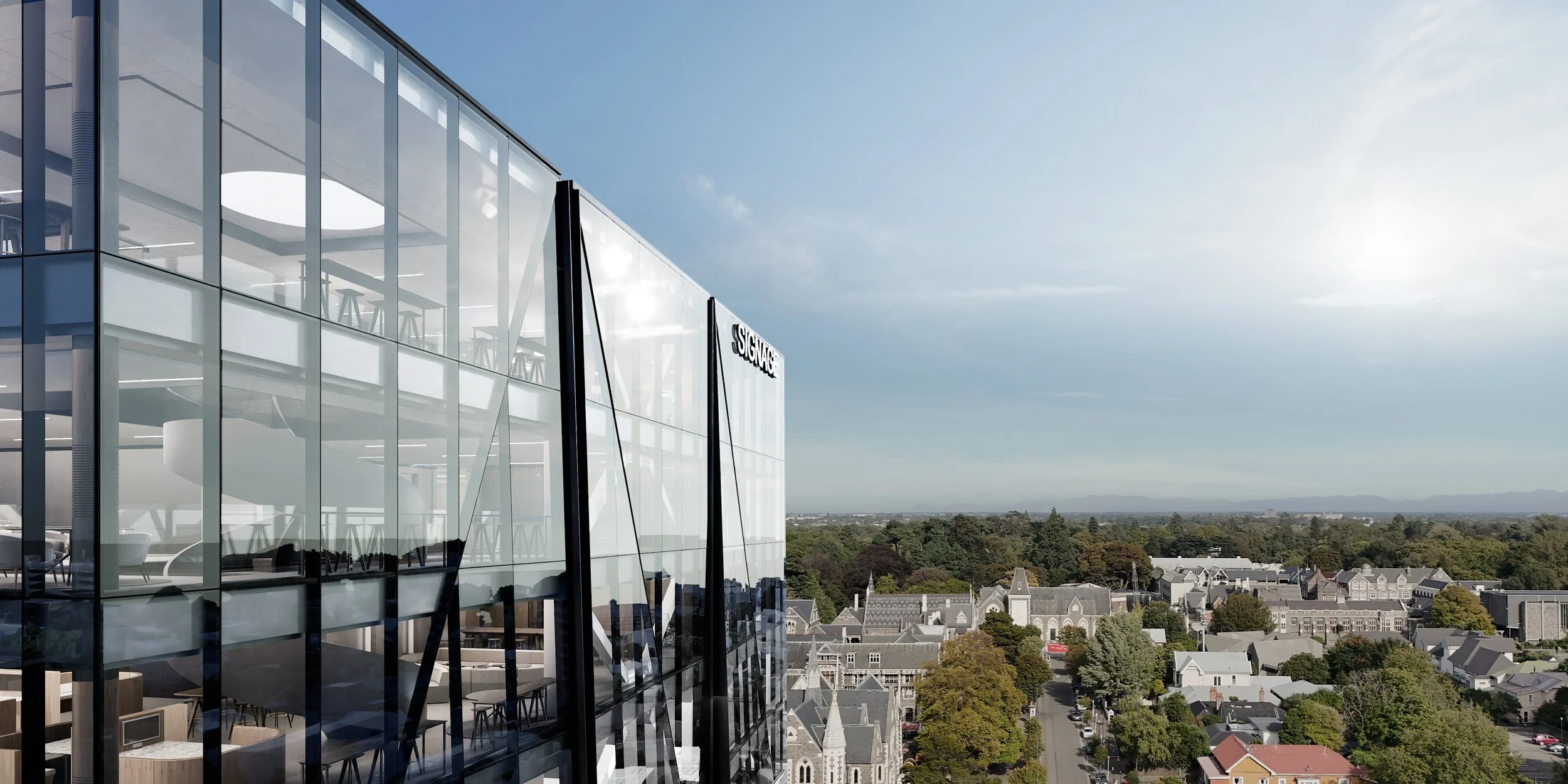 Modern glass building with "SIGNAGE" label, showing a cityscape view with trees, houses, and mountains in the background.