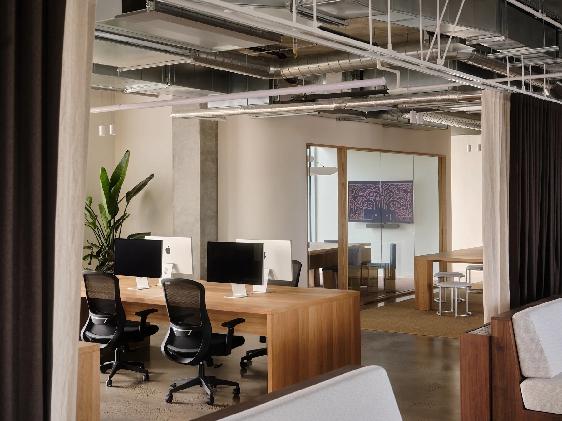 Open plan office at Programa HQ in Richmond, Melbourne, with American oak timber desks, polished concrete floors, exposed ductwork and glass meeting rooms.