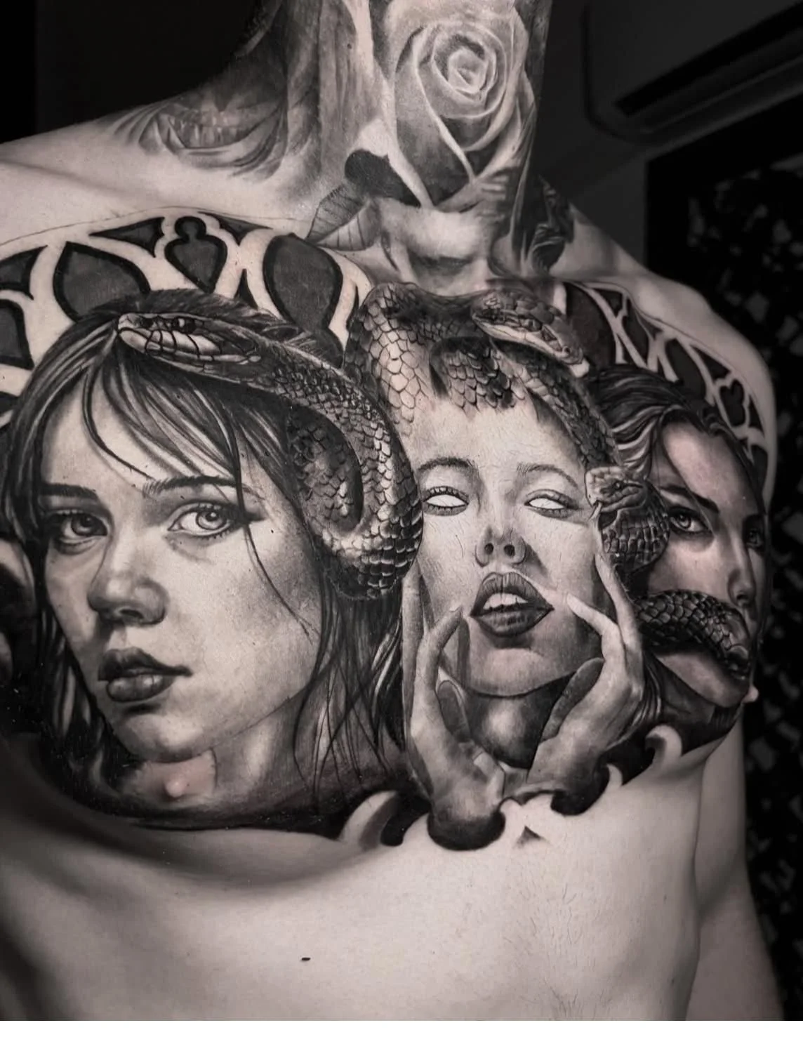 “Black and gray realism back tattoo featuring detailed female portraits and snake imagery, created by an artist at Salvation Tattoo Lounge in Miami Beach.”