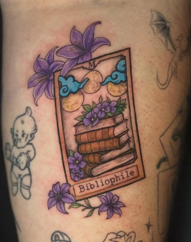 Color illustrative book and purple flower tattoo by Carol at Salvation Tattoo Lounge