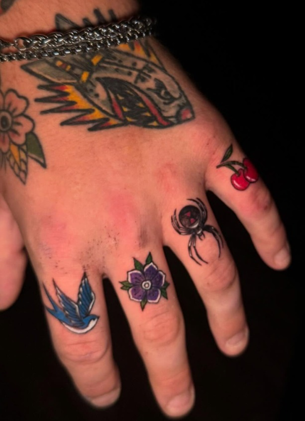 Small colorful finger tattoos featuring a bird, flower, spider and cherries by Carol