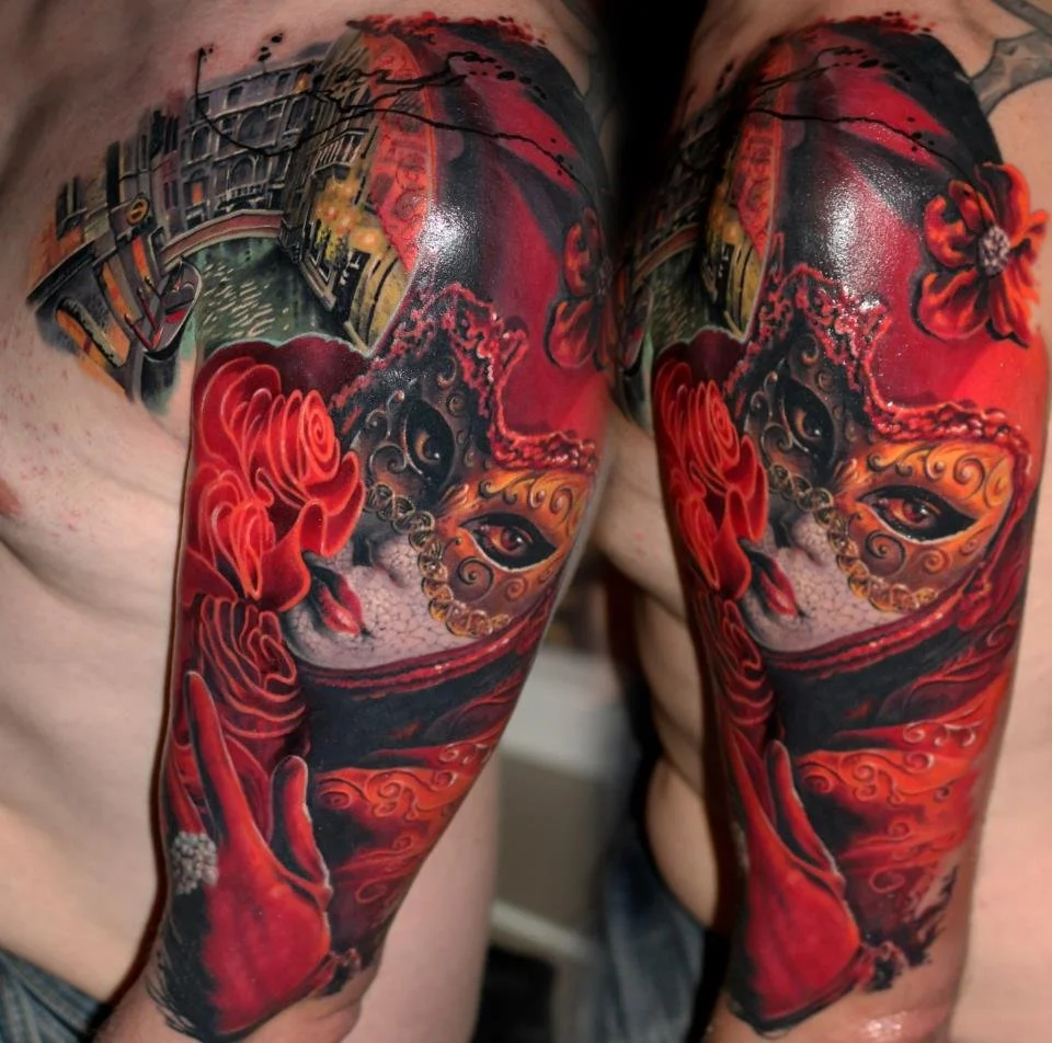 Color realism sleeve tattoo featuring a detailed Venetian mask design with rich red tones and custom illustrative elements