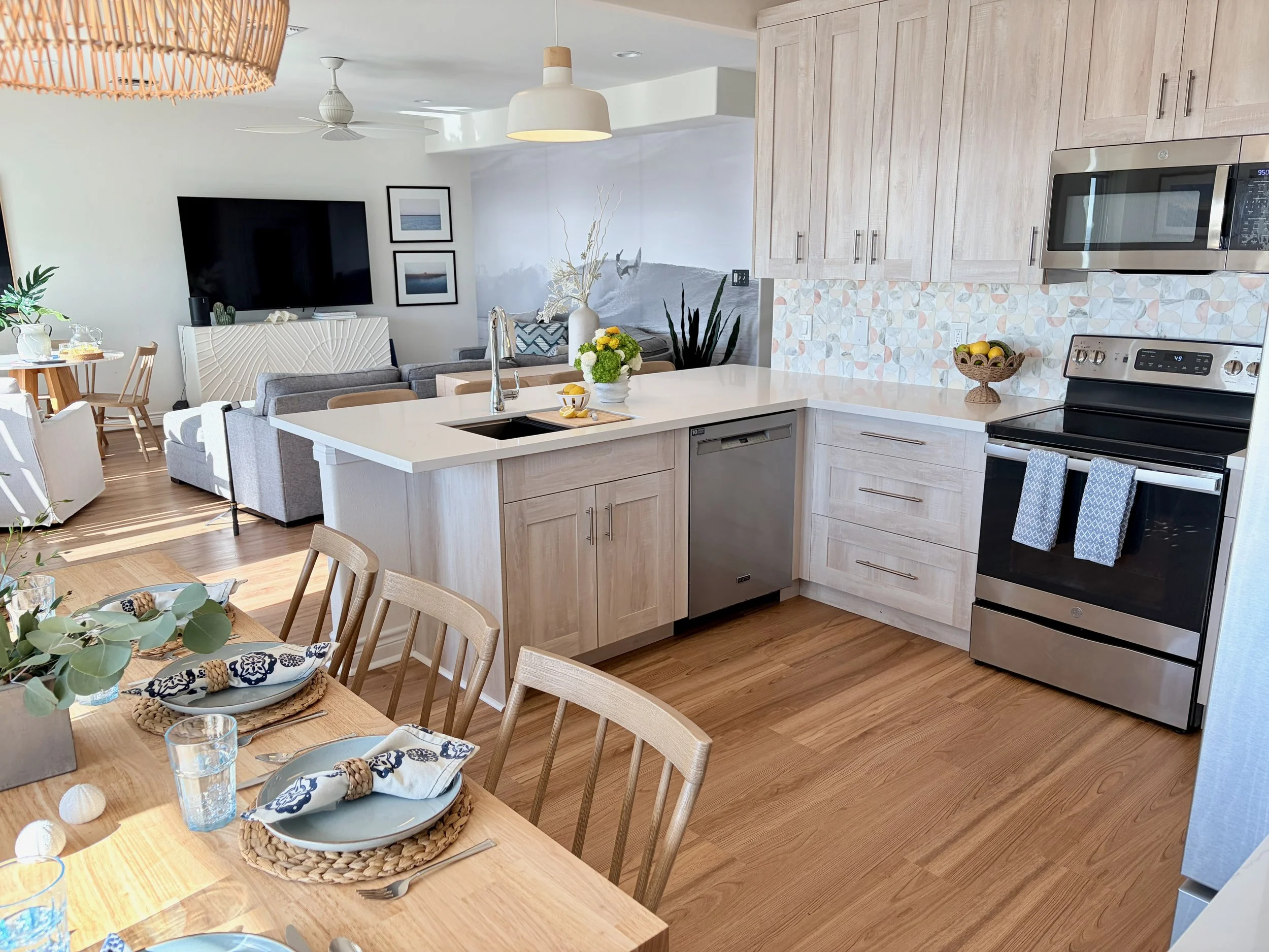 The kitchen flows into the dining area, featuring an island with seating for 4, banquette dining for 8, and additional seating in the living area for 4—ample room to host family meals. 
