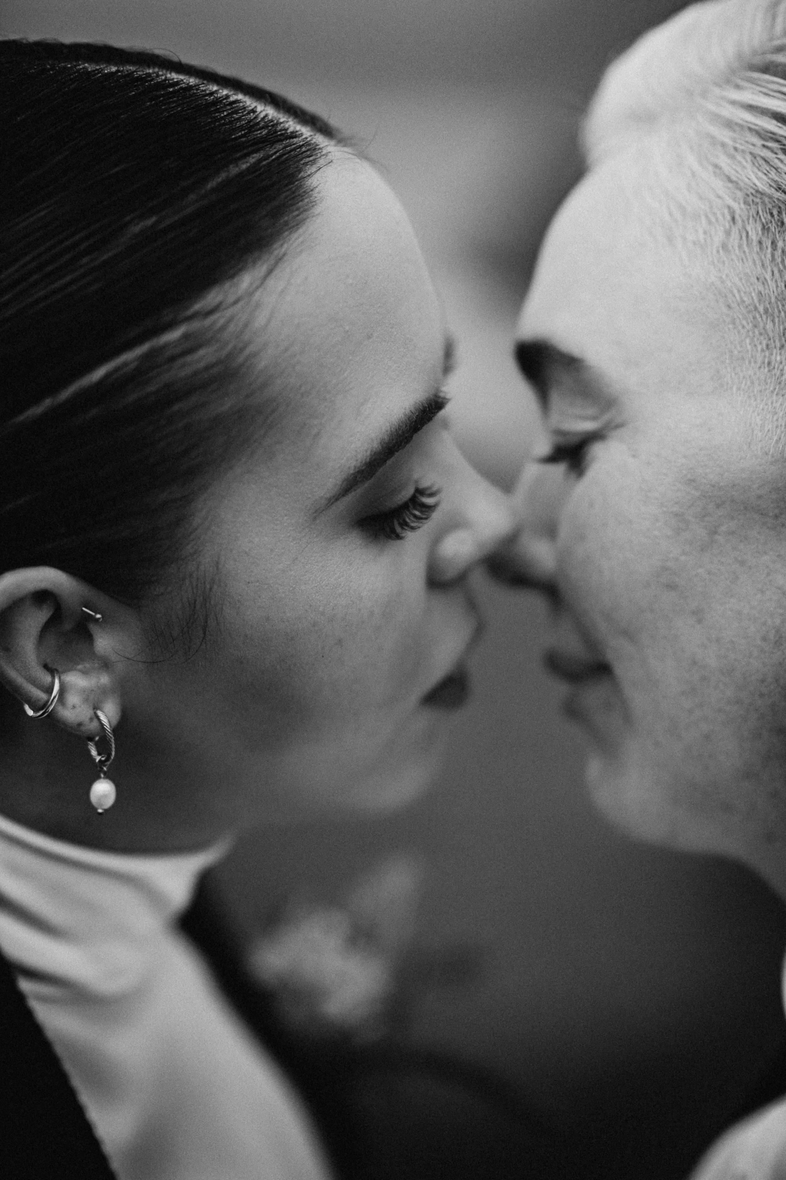 Close-up black and white photo of two people about to kiss.