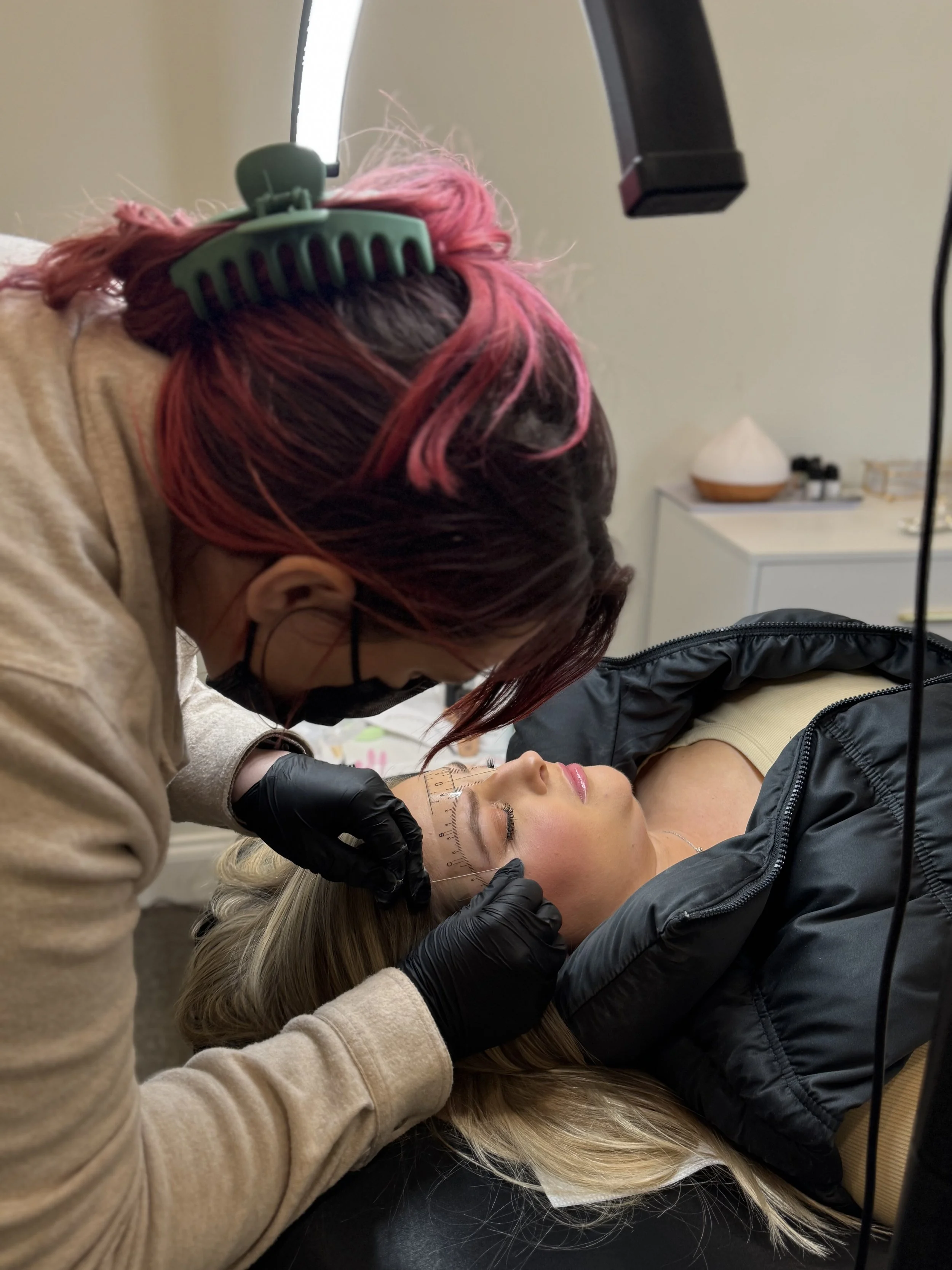 Caption: Students learning brow lamination and hybrid tint techniques at Bitty Beauty. Source: Bitty Beauty.