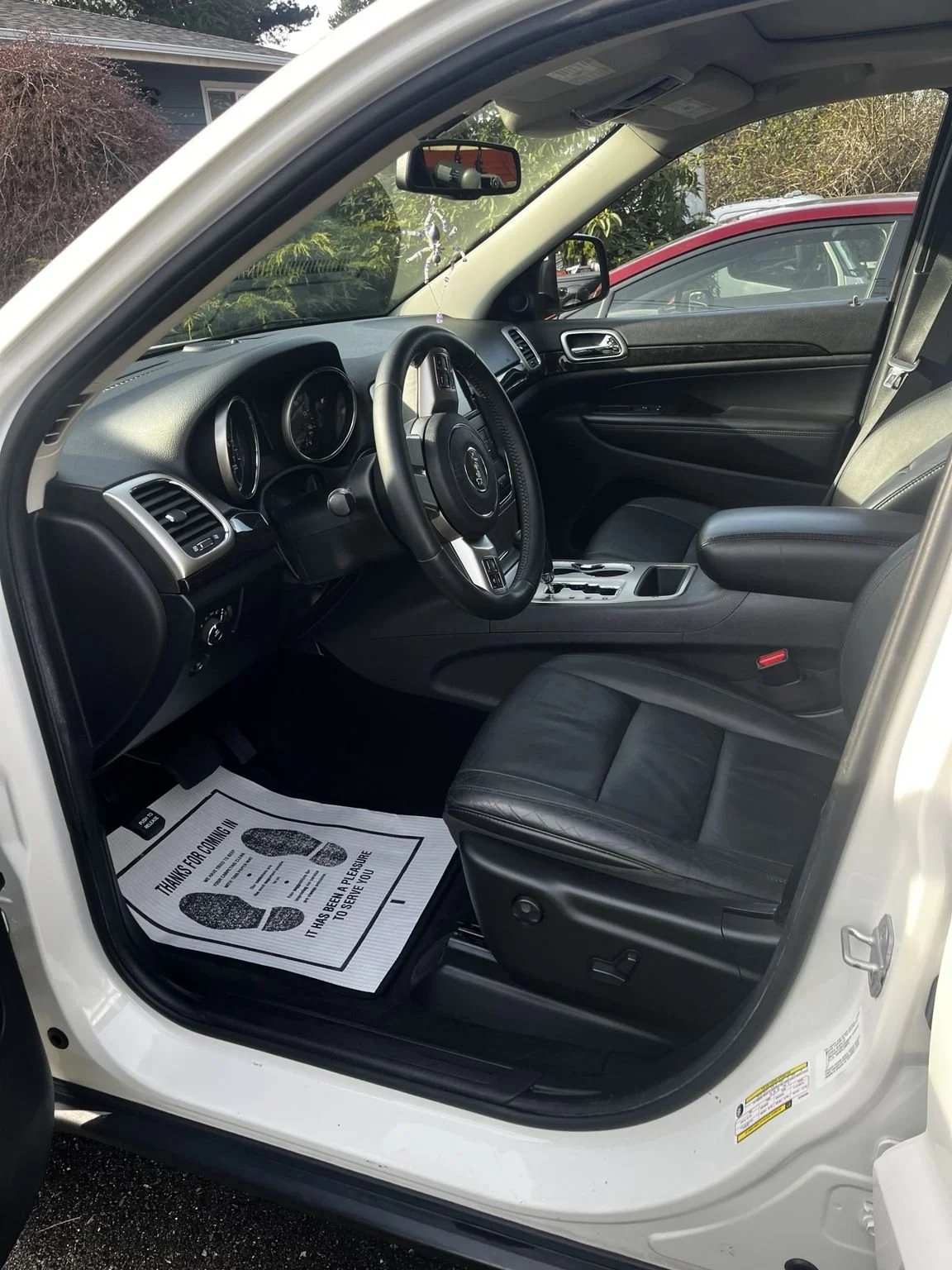 Mobile car detailing in Burien, WA -  interior detailing on Jeep Grand Cherokee with clean driver seat, dashboard, and floor mats