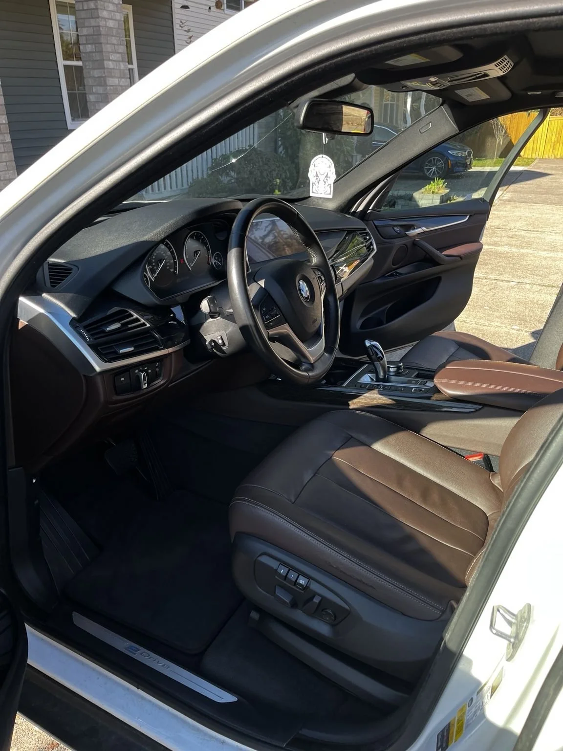Professional interior car detailing service in Maple Valley WA deep cleaning a BMW interior with spotless seats and dashboard.