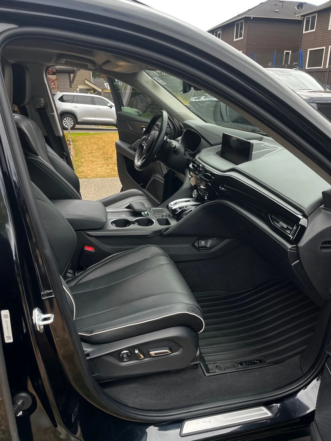 Clean Acura interior after professional detail, featuring spotless black leather seats and vacuumed floor mats by Bryanz Auto Detailing.